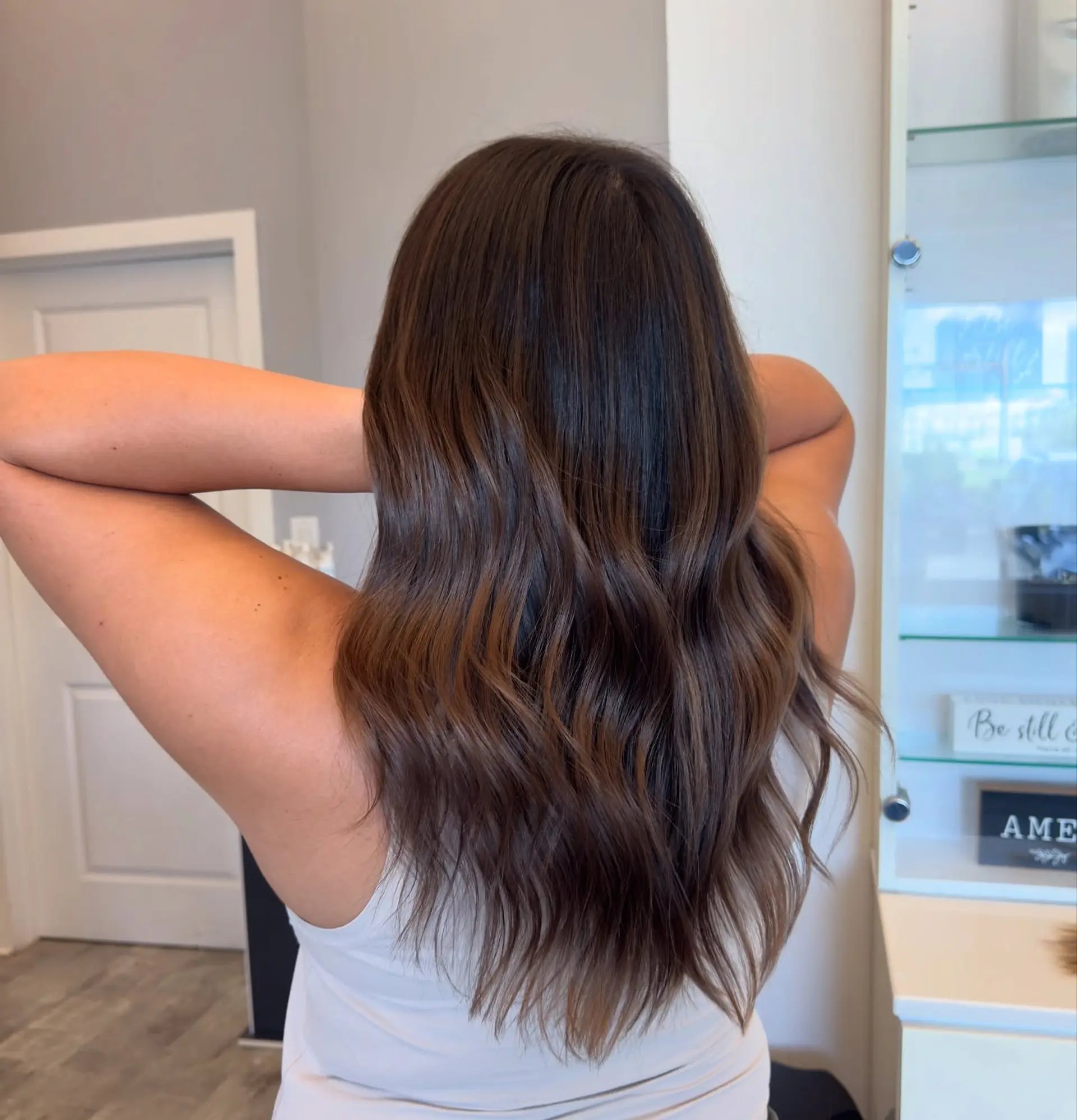 Long layered hair with subtle waves and a balayage bronde color melt. 3