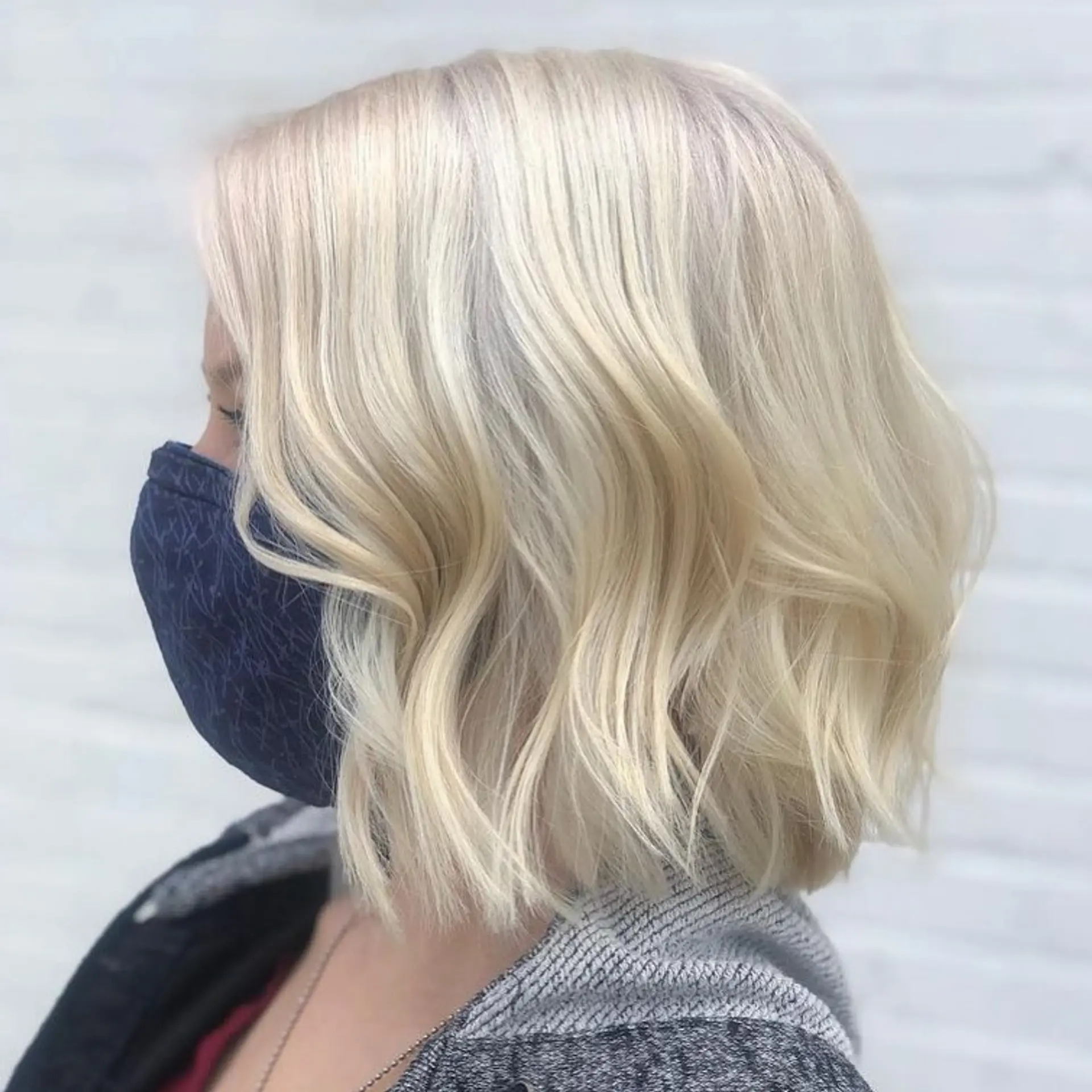 A bright platinum blonde bob haircut styled with soft, undone waves. 1