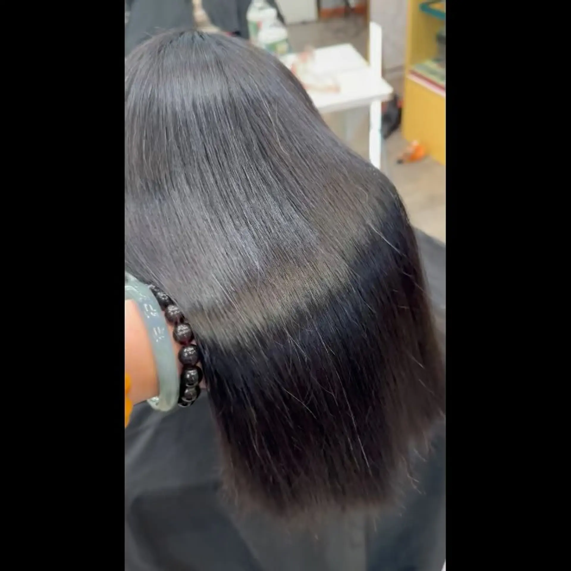 A sleek and glossy dark medium-length hairstyle with a super smooth, straight finish. 1