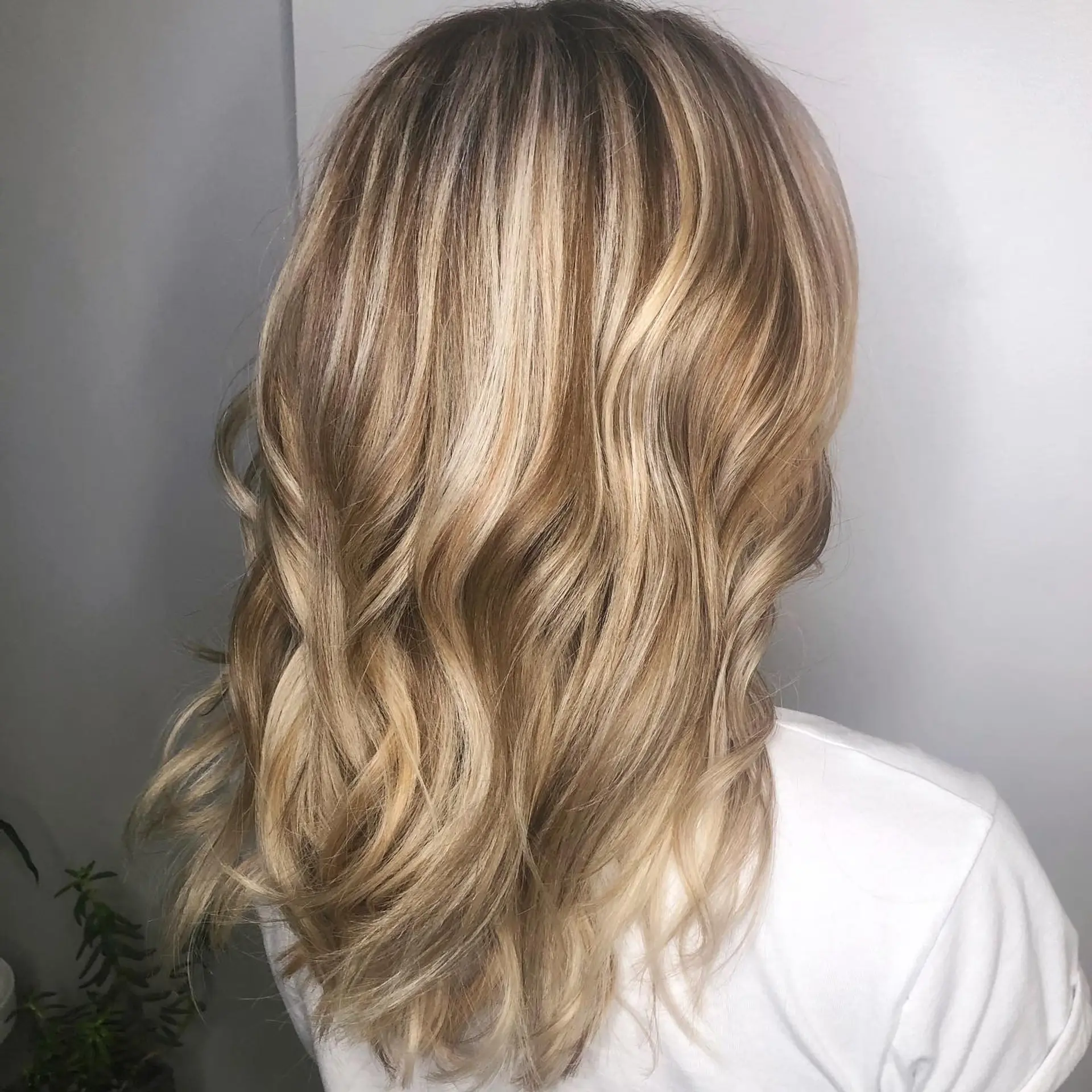 Medium-length warm blonde balayage styled in soft, loose beach waves. 1