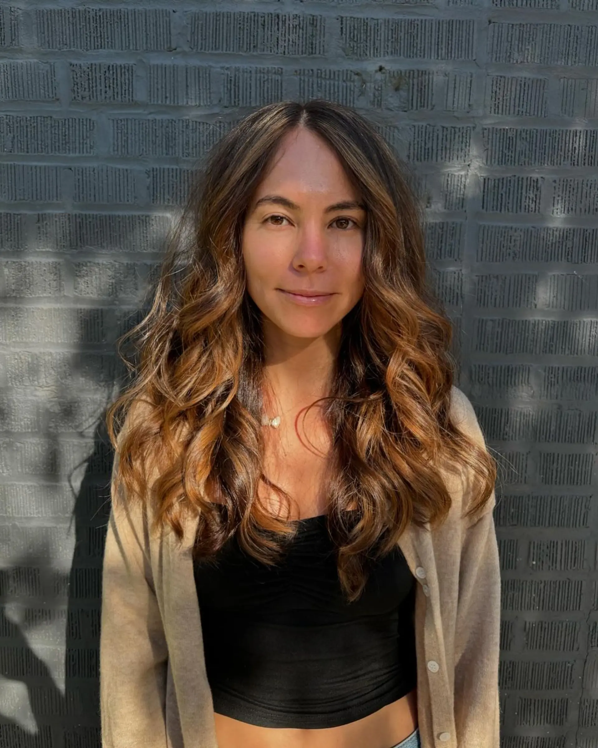 Long, wavy hair with a rich brown base and honey blonde highlights, creating a voluminous, sun-kissed effect with natural waves and a layered textured look. 2