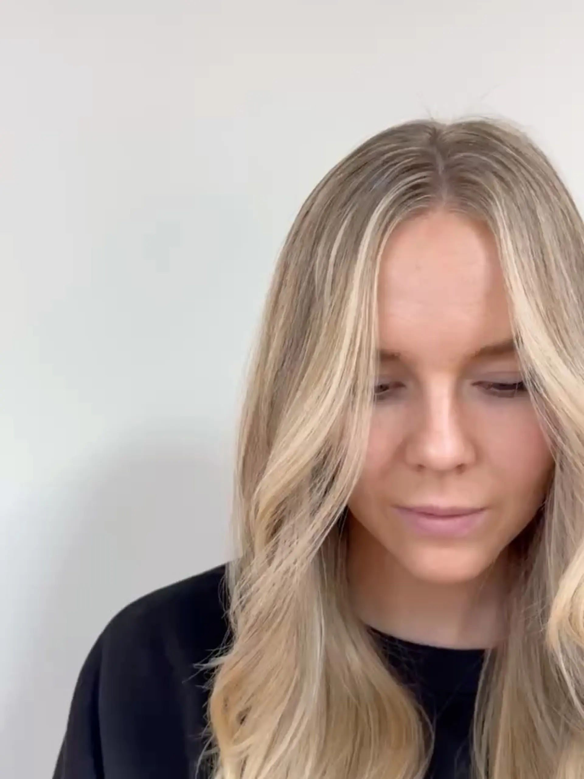 Long lived-in blonde hair parted down the middle with bright face-framing pieces and soft waves. 1