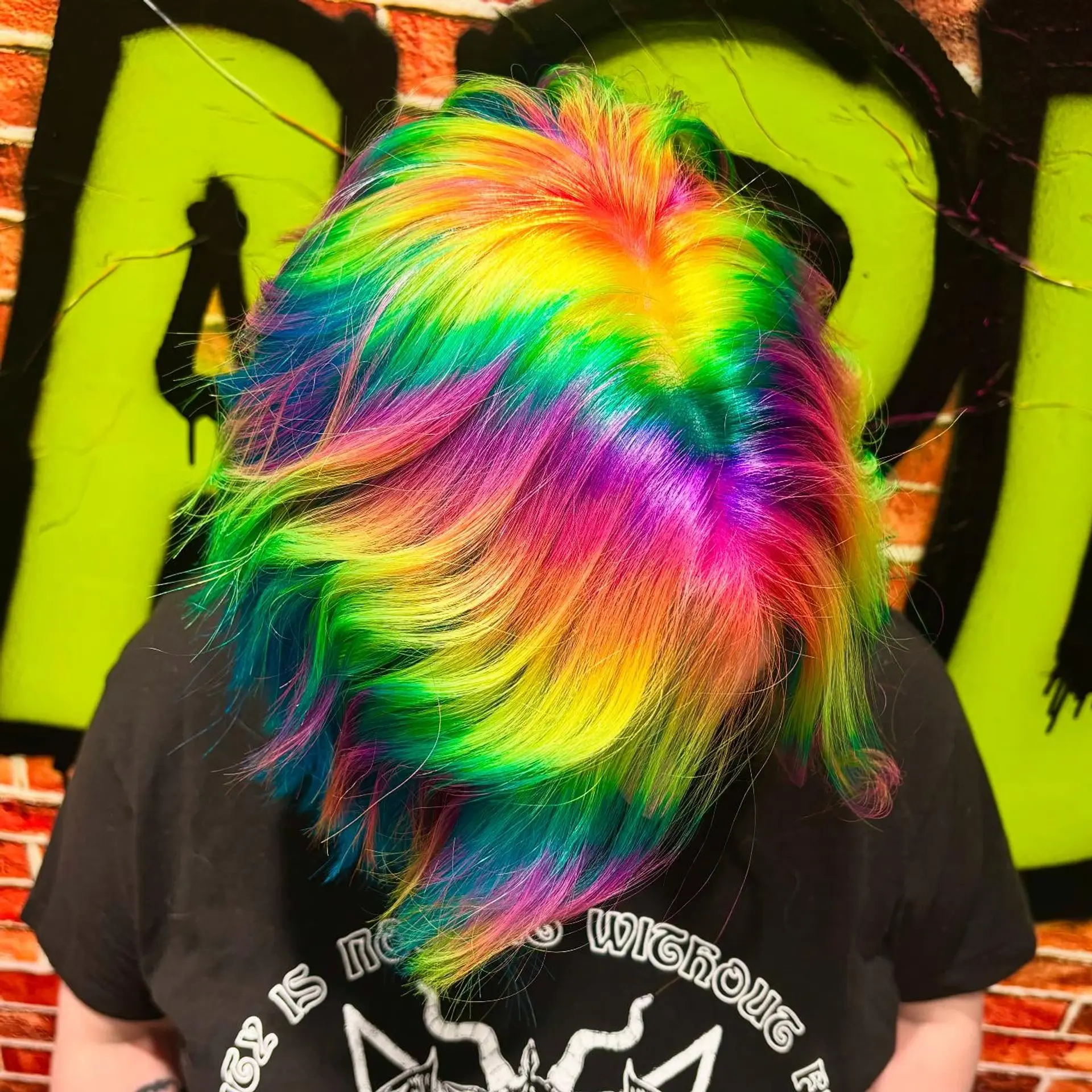 A vibrant holographic rainbow color effect dyed across a short layered cut. 1
