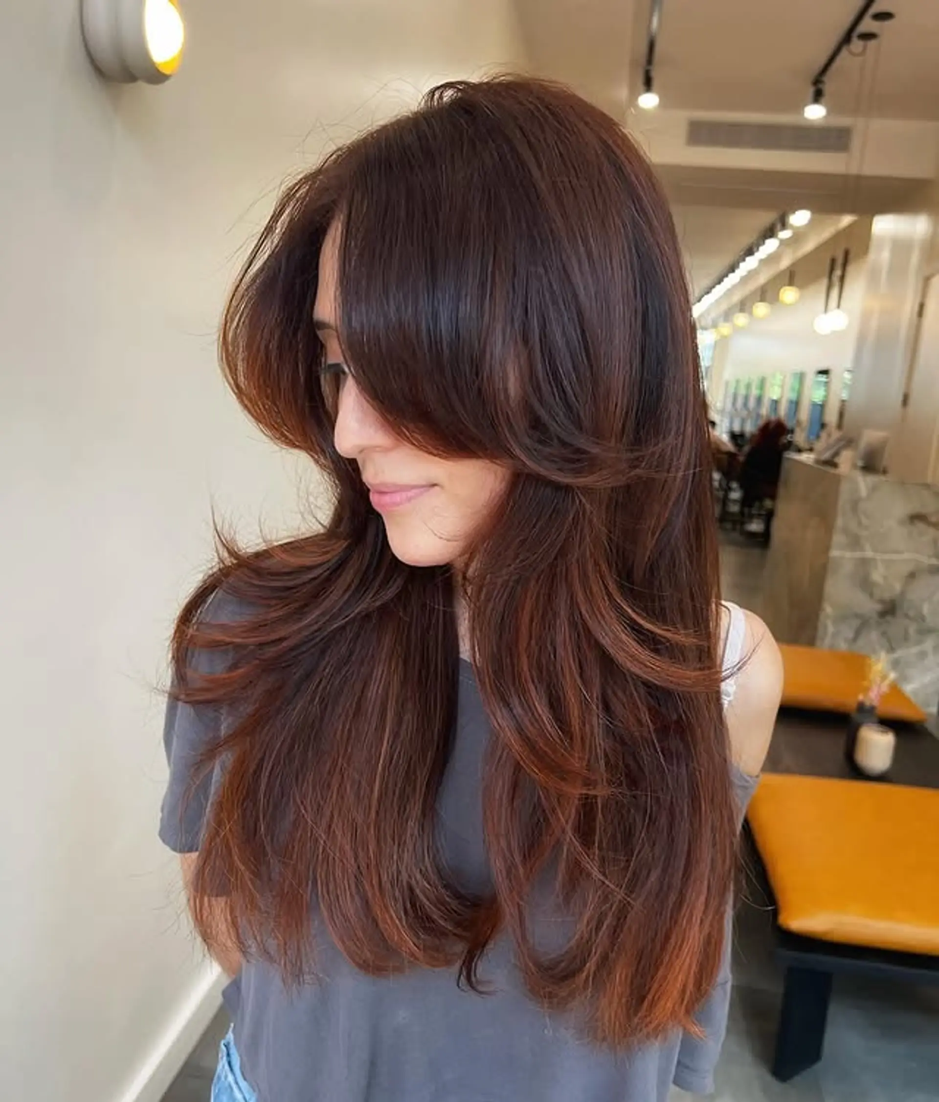 A long, layered cut featuring curtain bangs and face-framing layers. 1