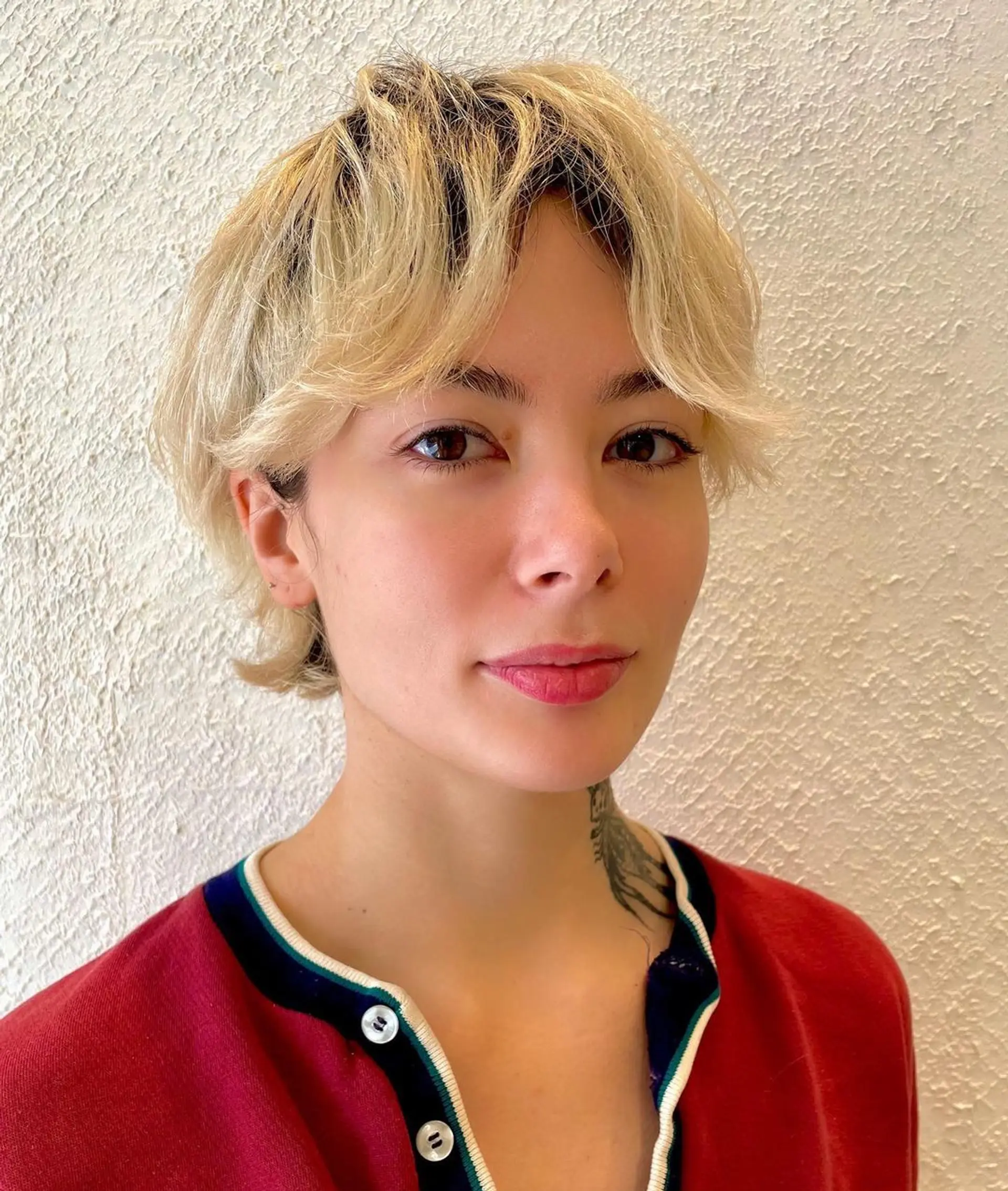 A short, wavy hairstyle with soft, tousled layers. Blonde in color, it has face-framing strands and a natural, casual finish. 1