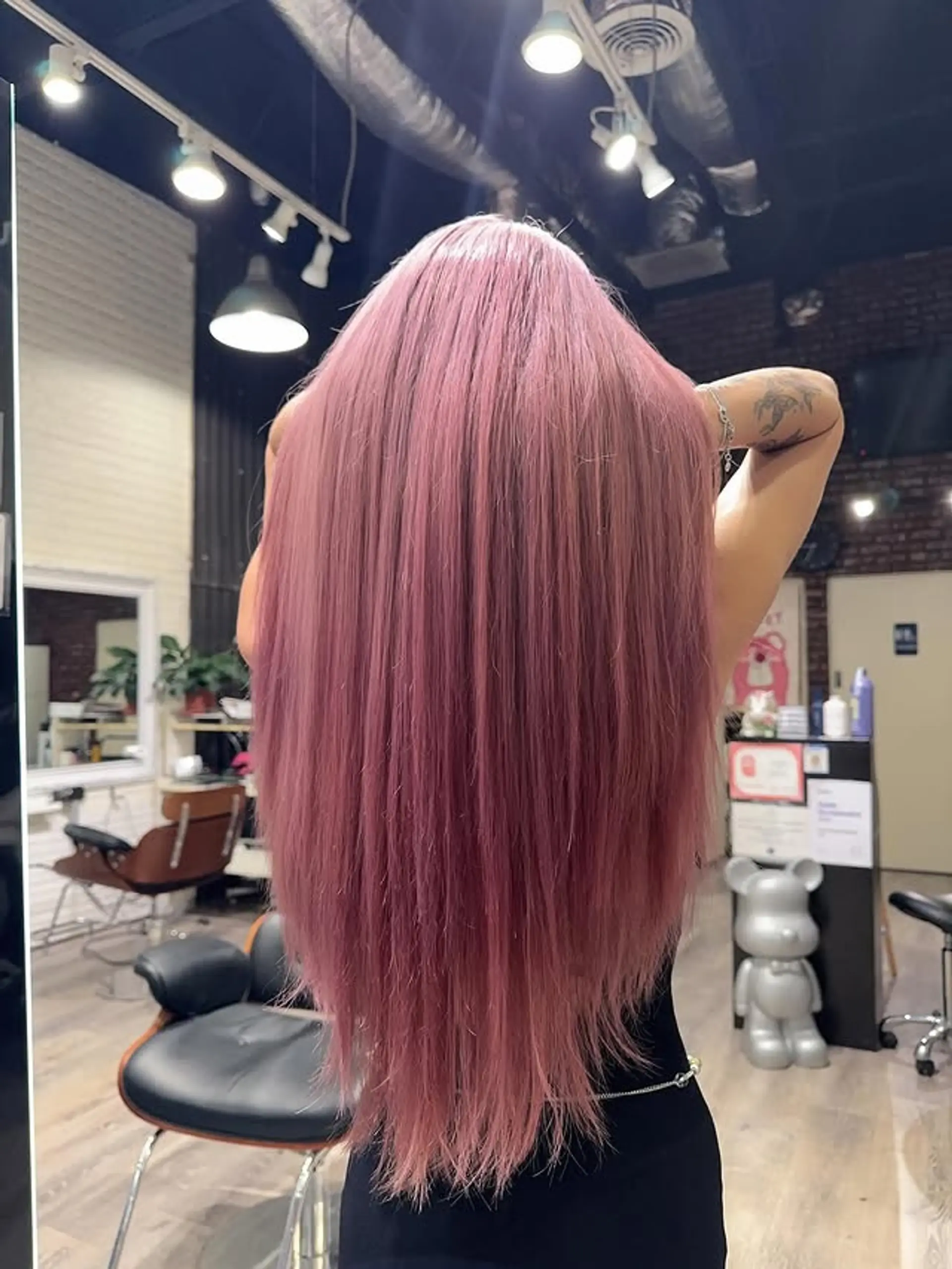 This hairstyle showcases very long, straight, and sleek hair dyed in a stunning, vibrant rose gold and pink color, extending well past the waist. The color is rich and even throughout. 1