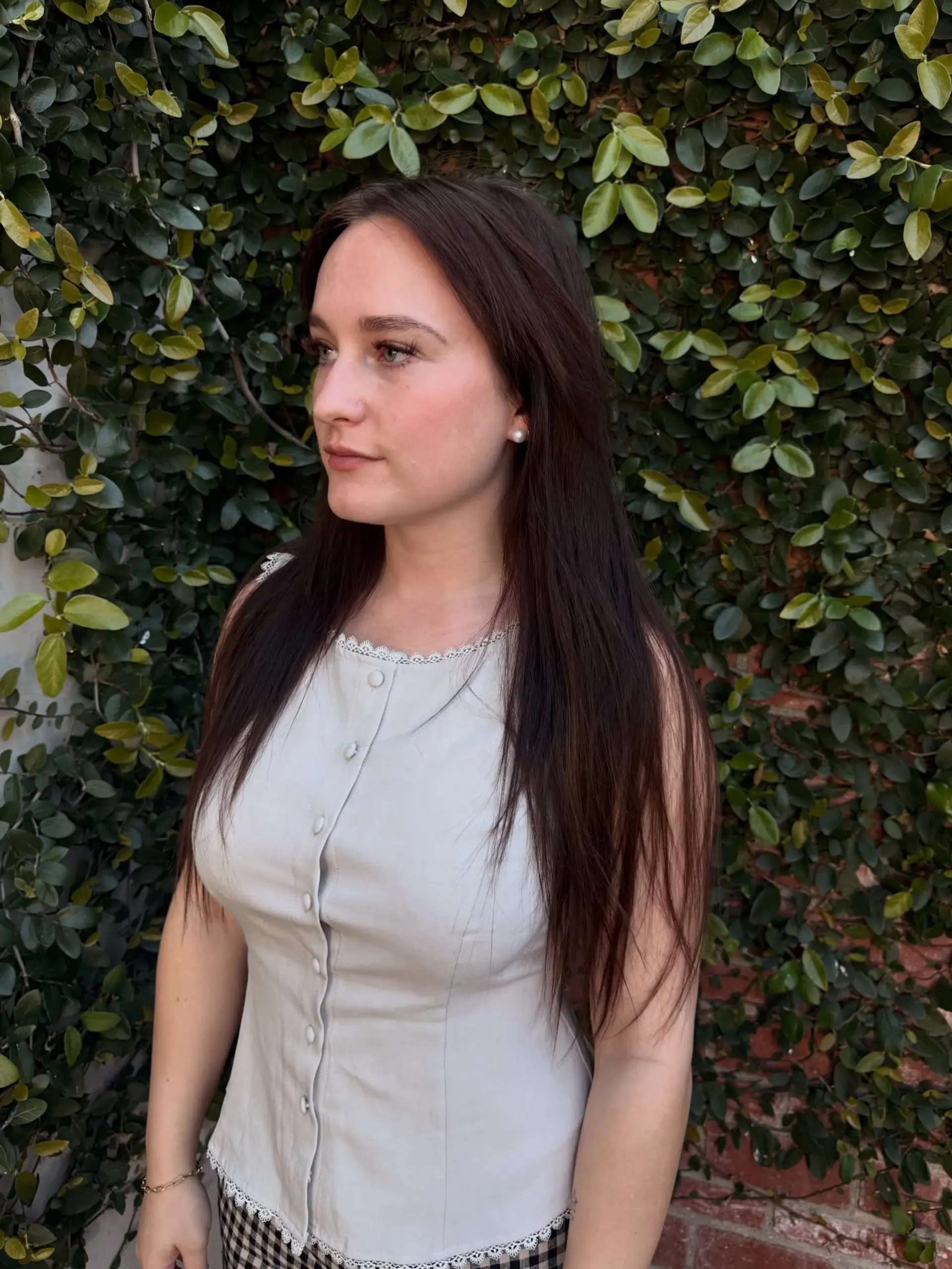 Long, dark brown hair styled straight with a center part and soft, layered ends. 1