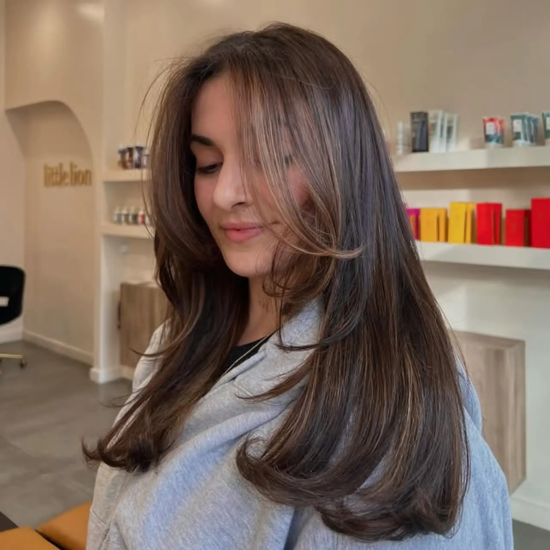 Long, layered brunette hair with strategically placed face-framing blonde highlights. 1