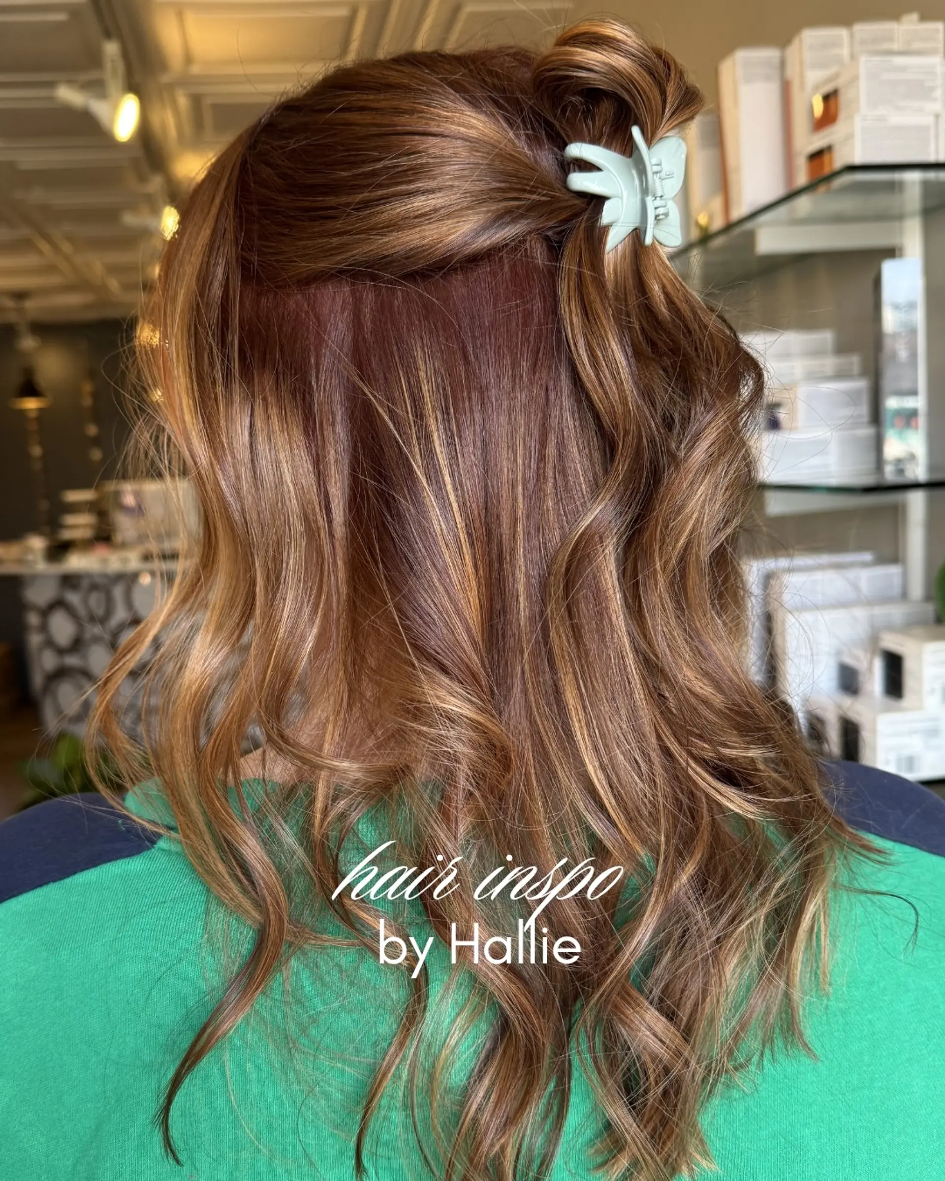 Long warm brunette hair with dimensional caramel highlights styled in loose waves and partially pinned up with a claw clip. 1
