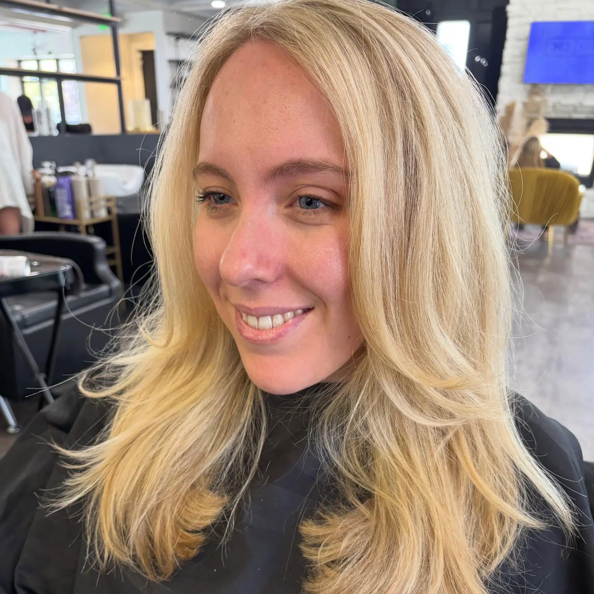 Long golden blonde hair cut with face-framing layers and styled in a soft, voluminous blowout with flipped ends. 1