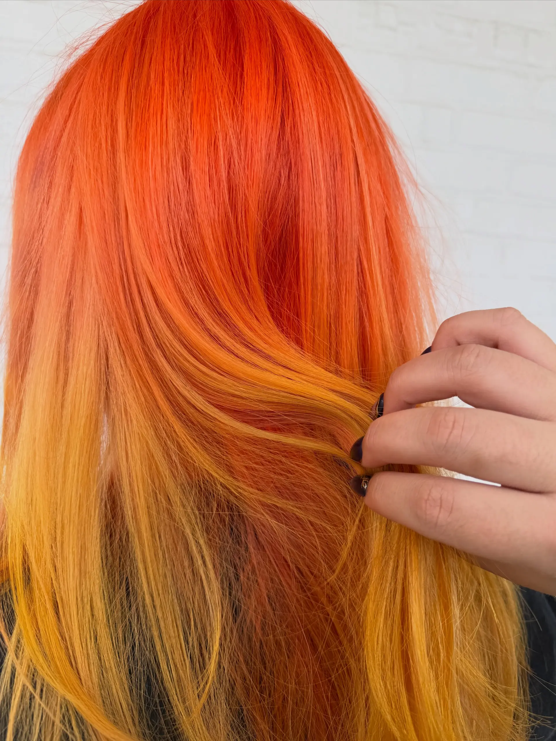 Vibrant, electric orange hair with warm yellow undertones, styled straight to showcase the smooth color blend. 1