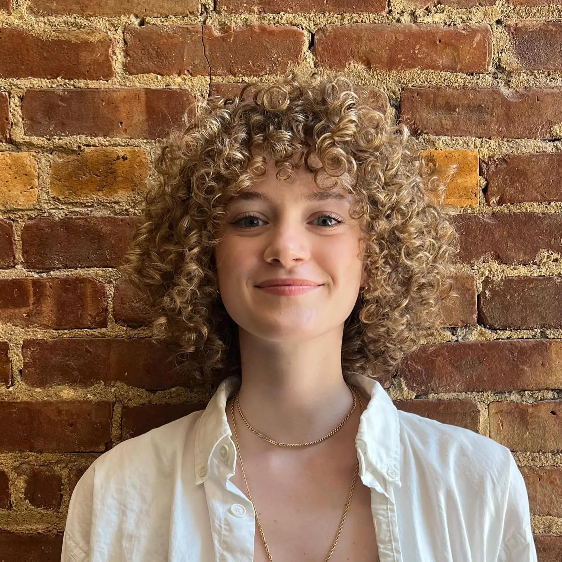 A shoulder-length curly hairstyle with defined ringlets and a full curly fringe. 1
