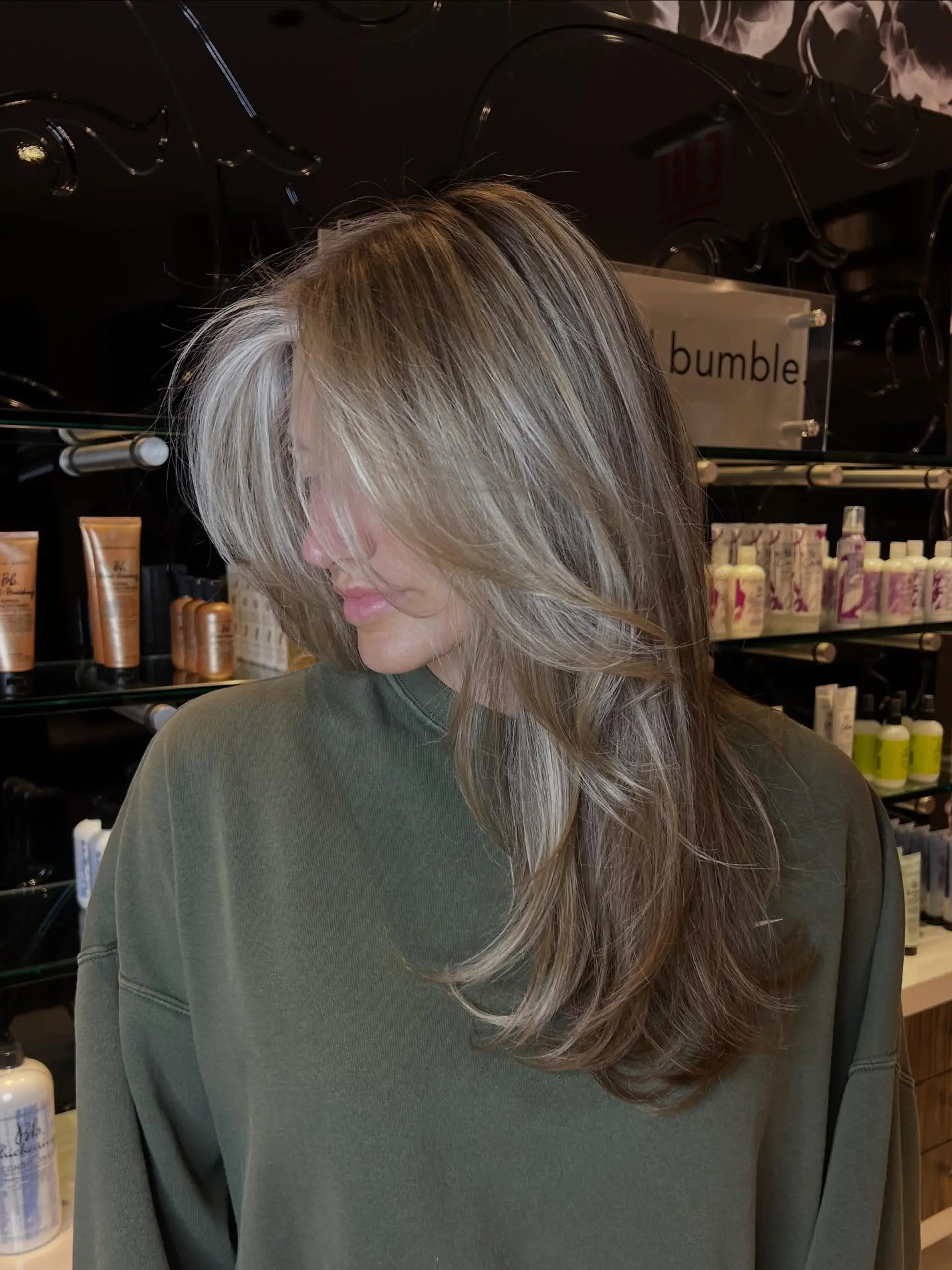 Long layered blowout featuring cool-toned dimensional blonde highlights and a striking bright money piece. 1