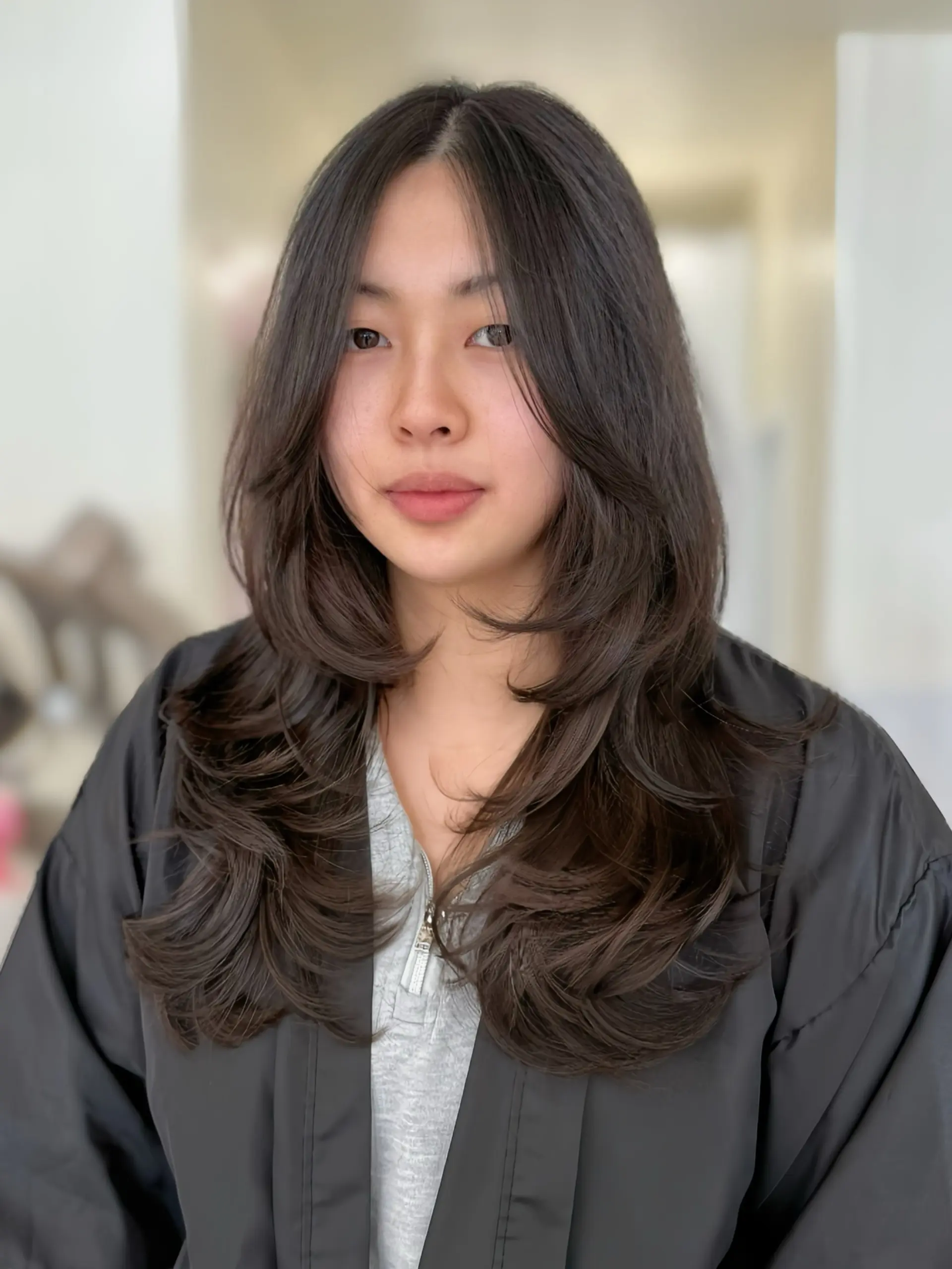 Long layered dark hair styled with inward-curling C-curls and face-framing layers. 1