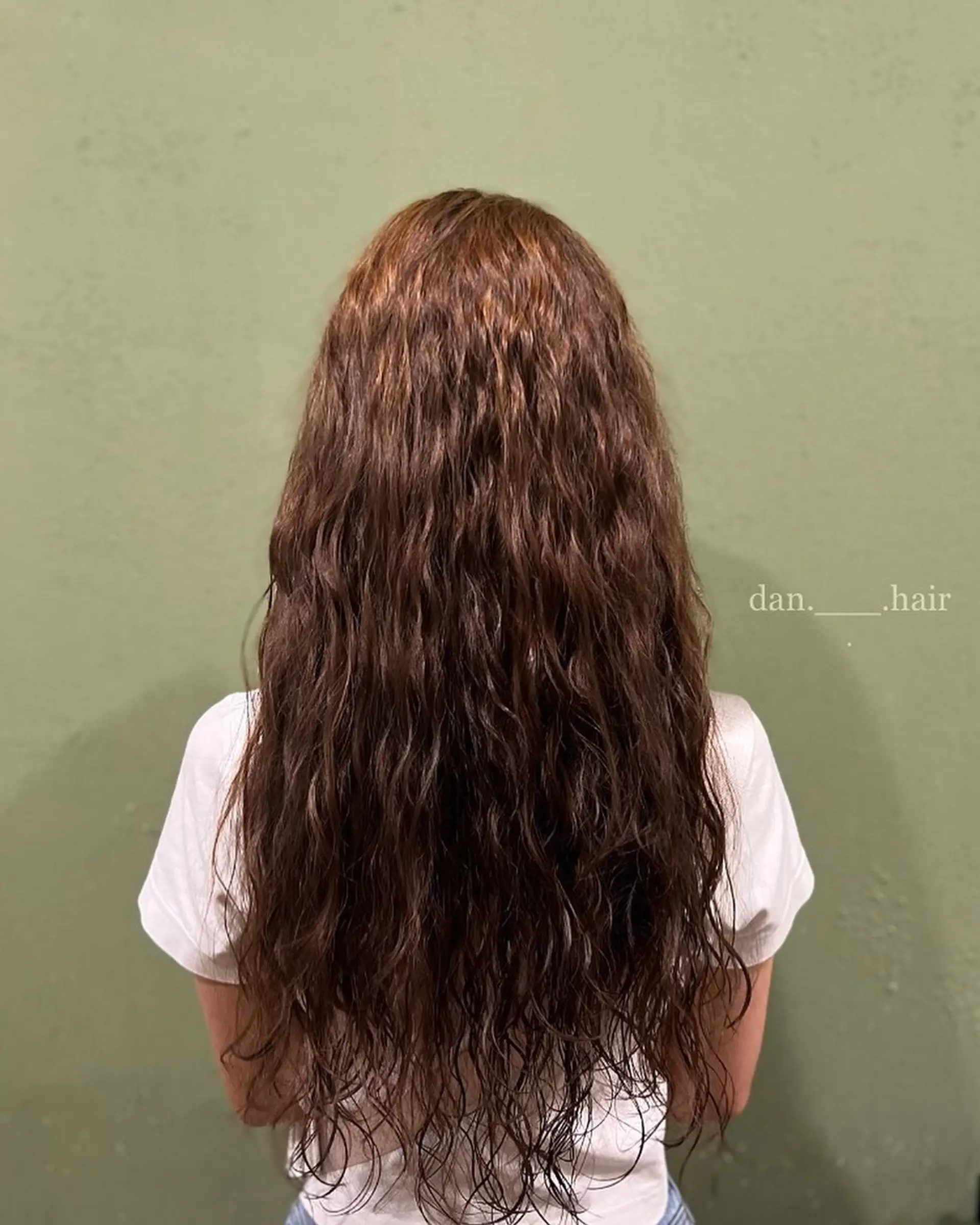 Long warm brown hair treated with an all-over digital hippie perm creating tight, crimped waves from crown to ends. 1