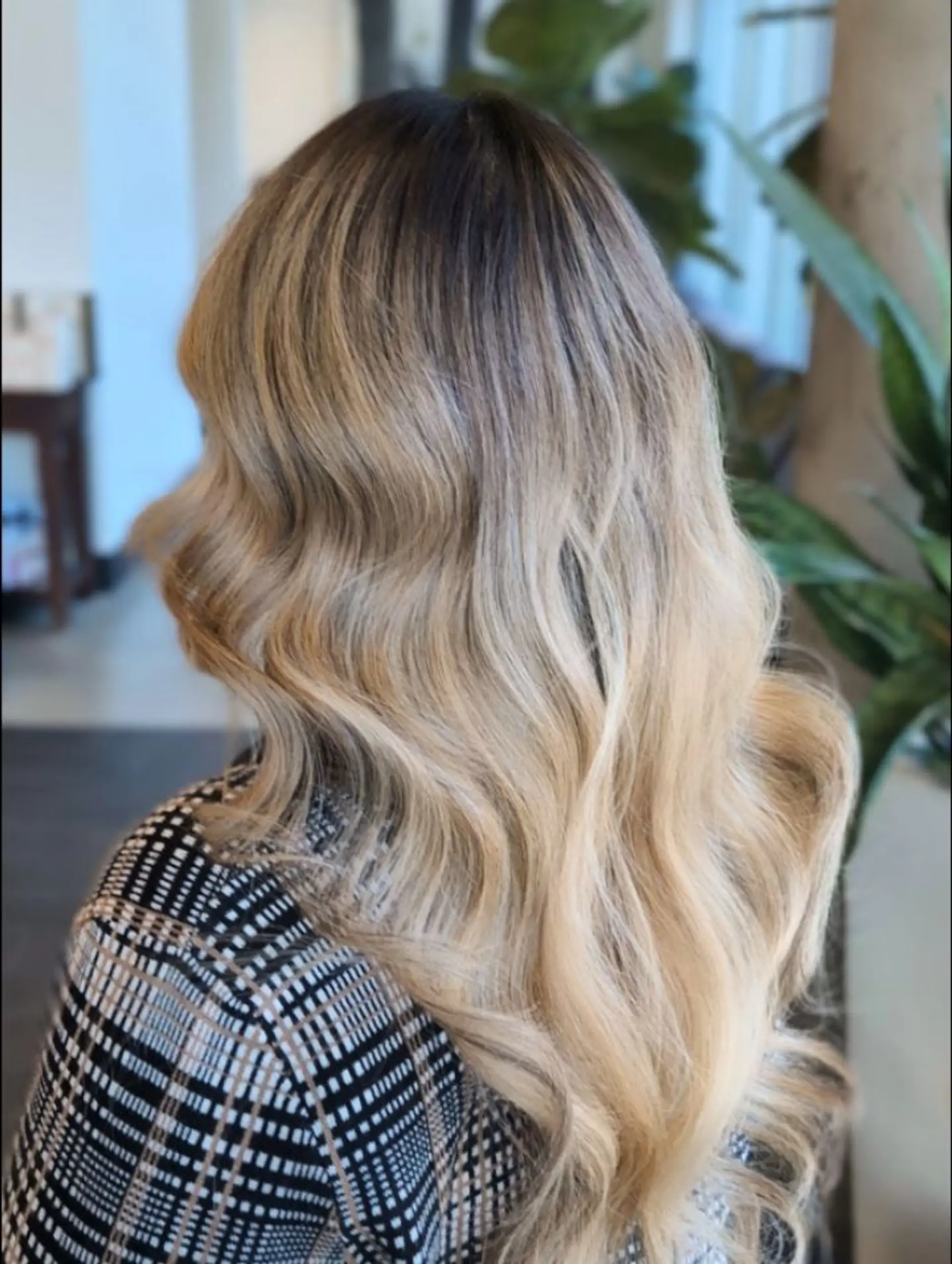Long dimensional blonde hair styled in soft, brushed-out waves with a natural shadowed root. 1