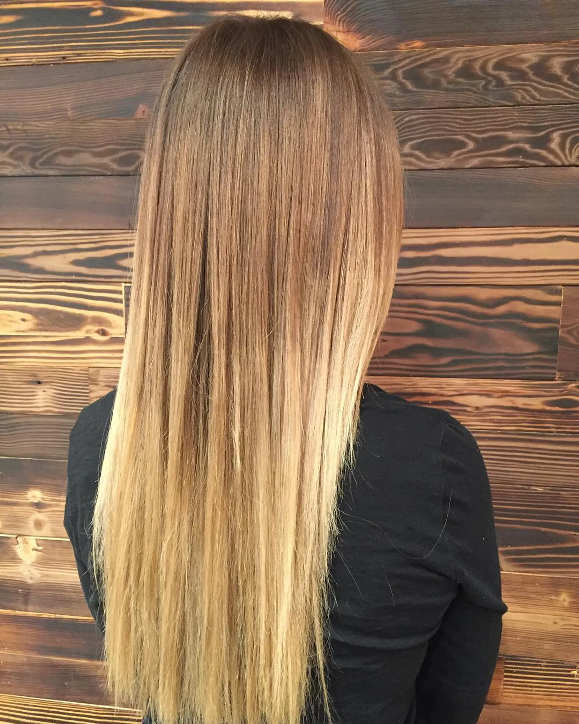 A very long, straight hairstyle with a balayage that transitions from brown to blonde. 1