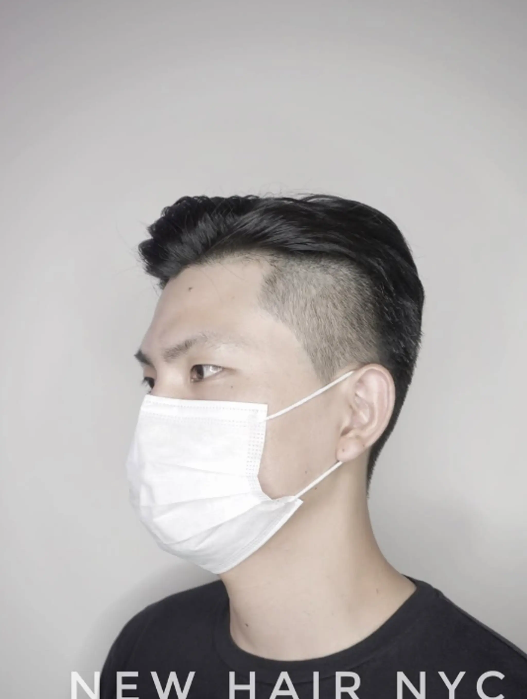 Features a clean taper fade on the sides and back, with the hair on top styled slicked back.