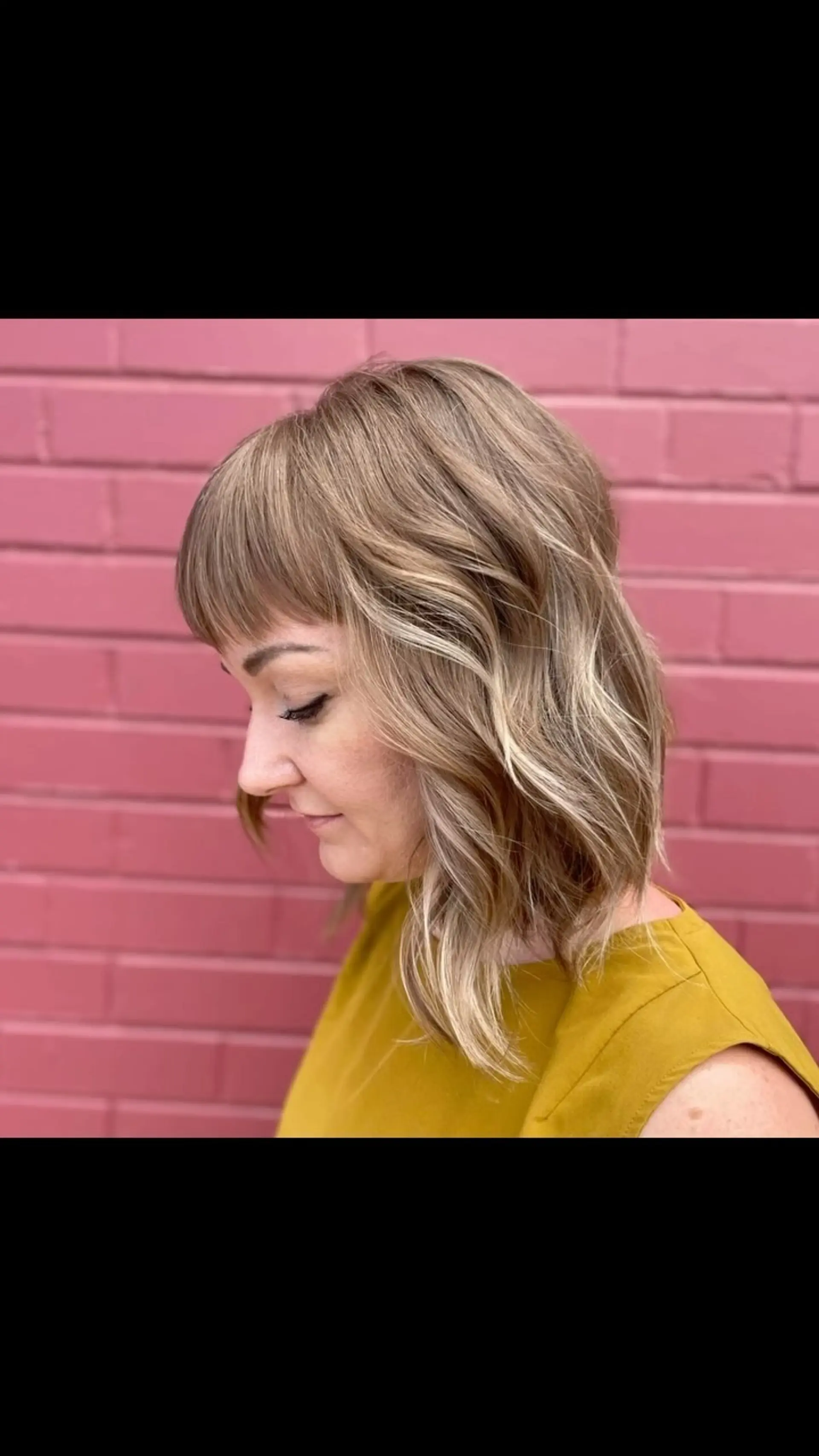 A textured shoulder-length lob with soft waves, micro fringe, and dimensional lived-in blonde teasylights. 1
