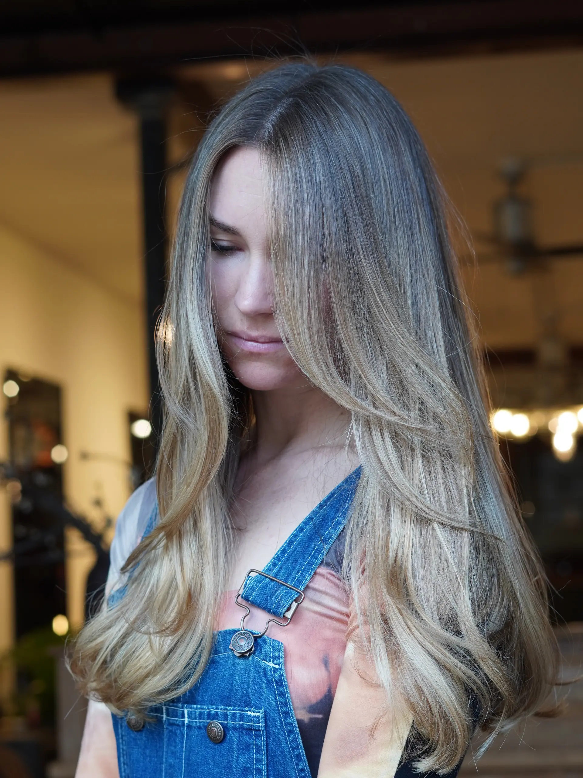 Long hair featuring soft lived-in blonde highlights with blended face-framing layers and styled ends. 1