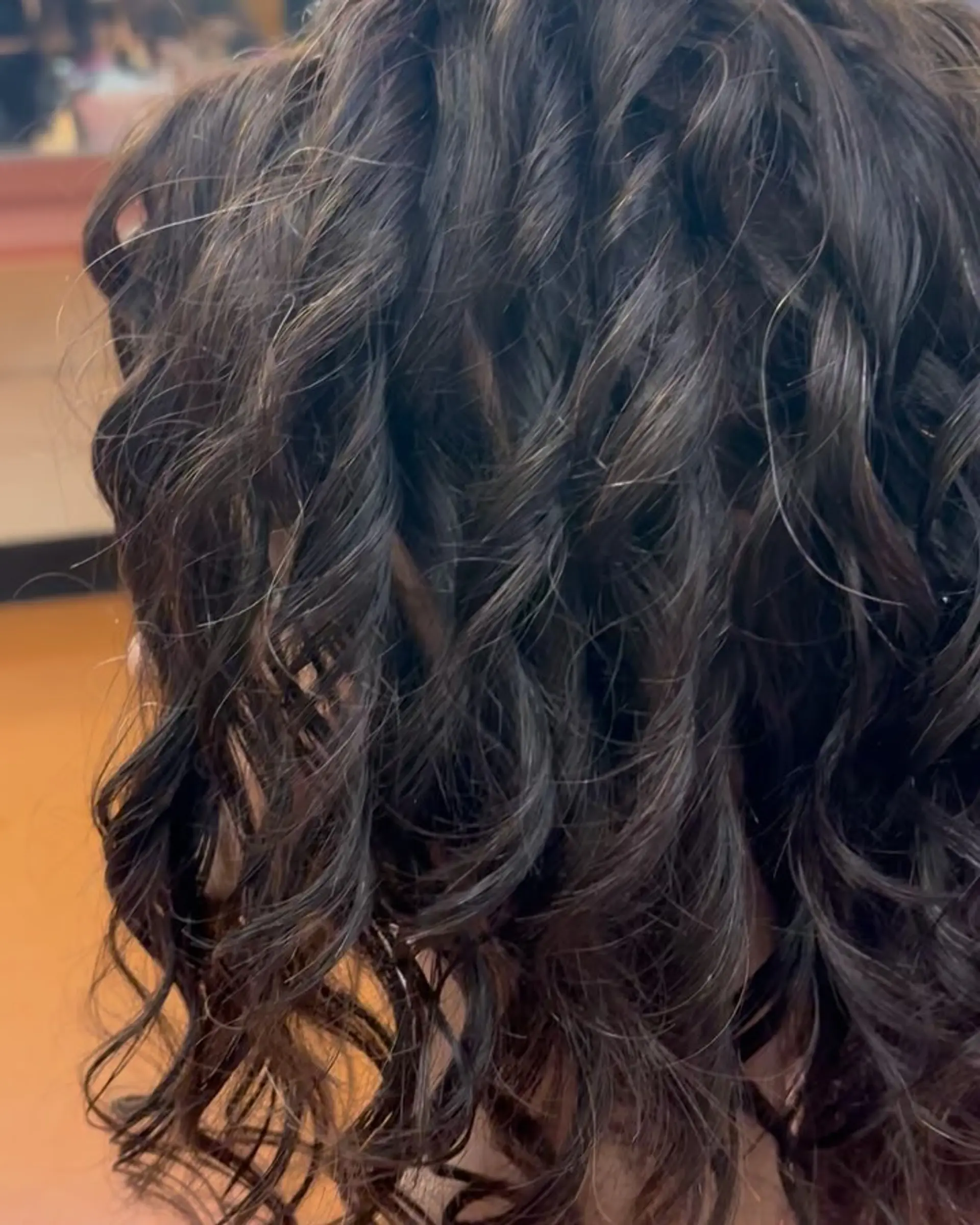 Medium-length defined spiral curls with rich dark brunette tones. 1