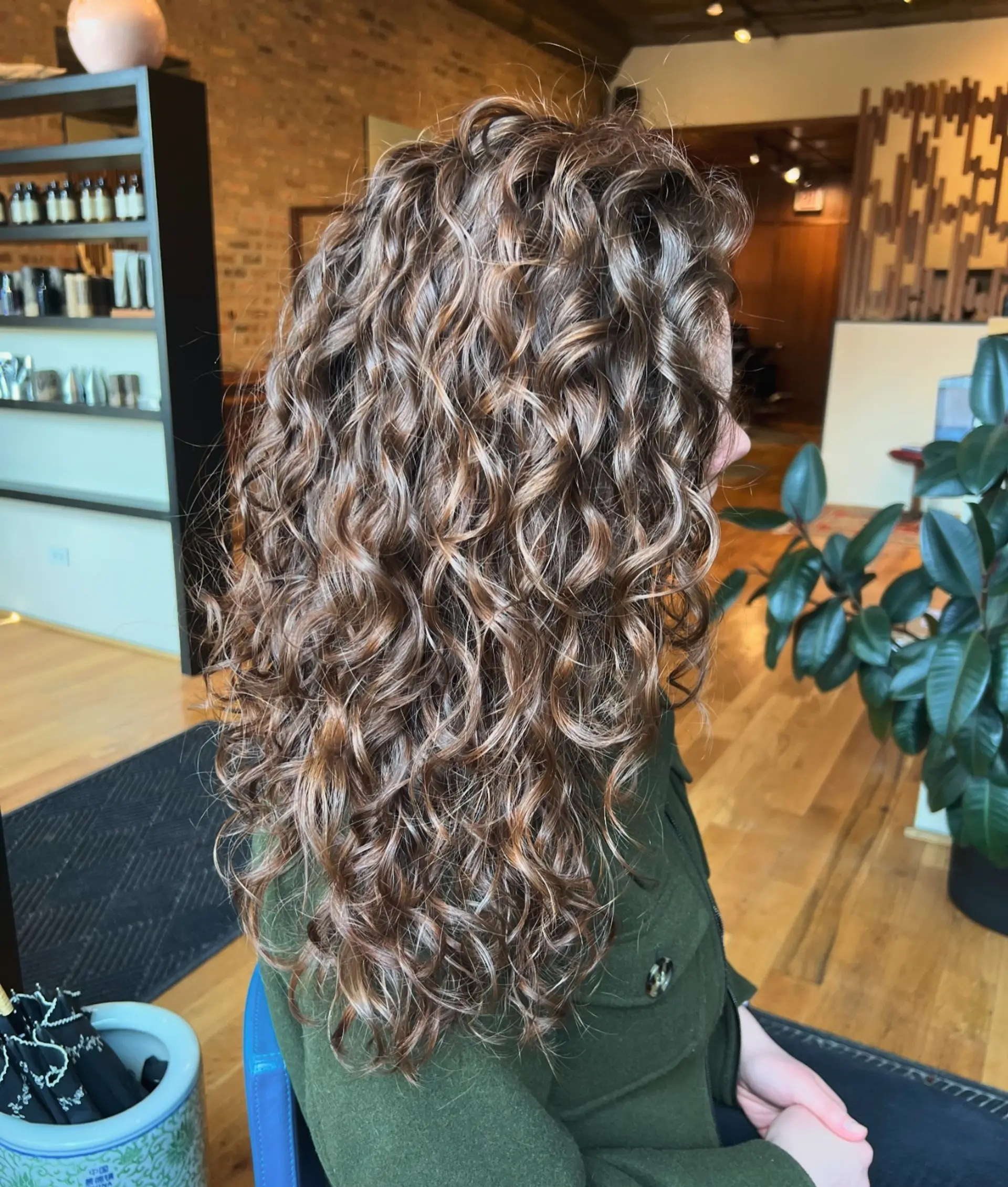 This long, layered curly hairstyle features a beautiful balayage effect that enhances the natural curls. 1