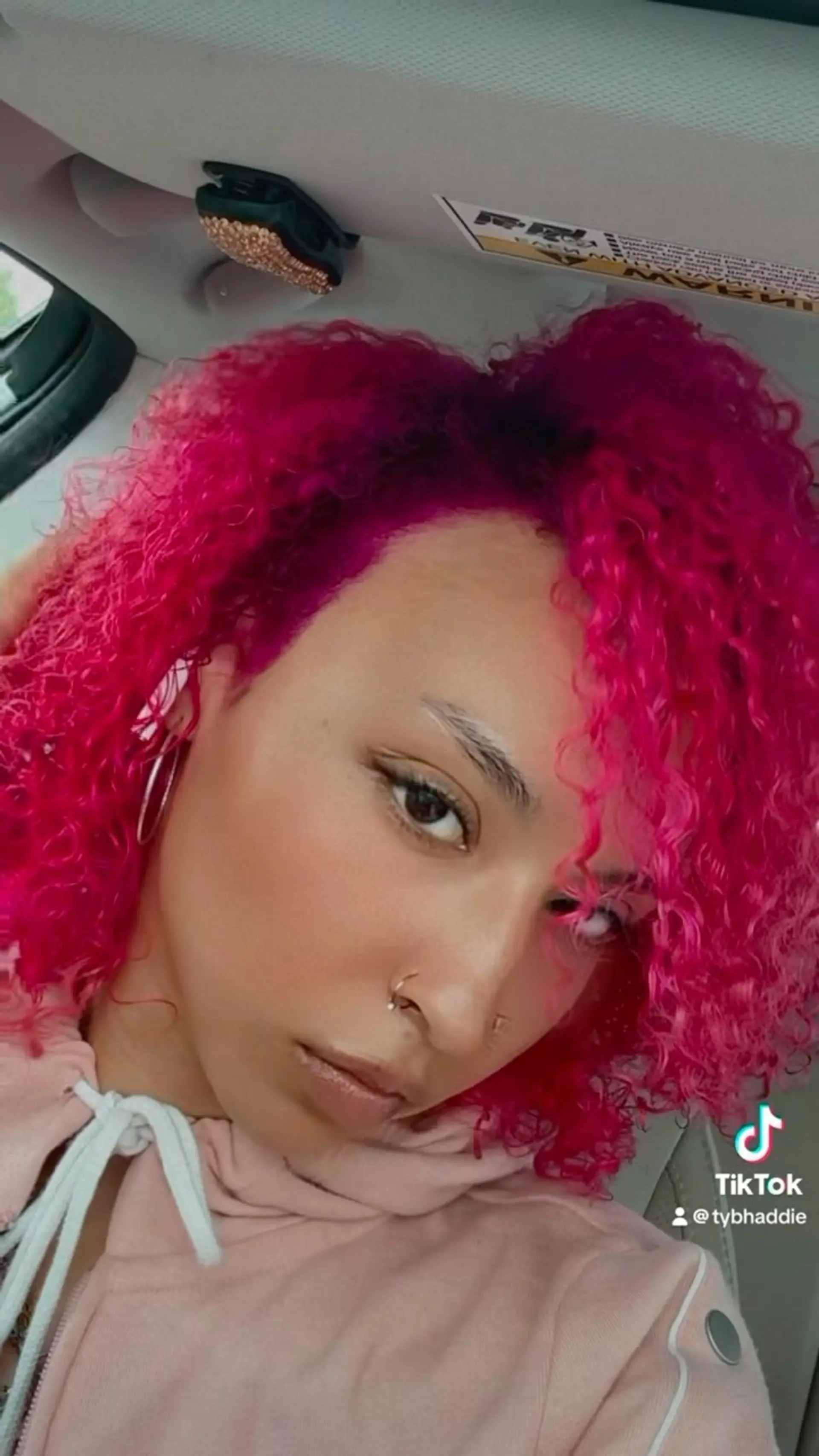 Vibrant, bright magenta-pink curls styled into a defined curly cut framing the face. 1