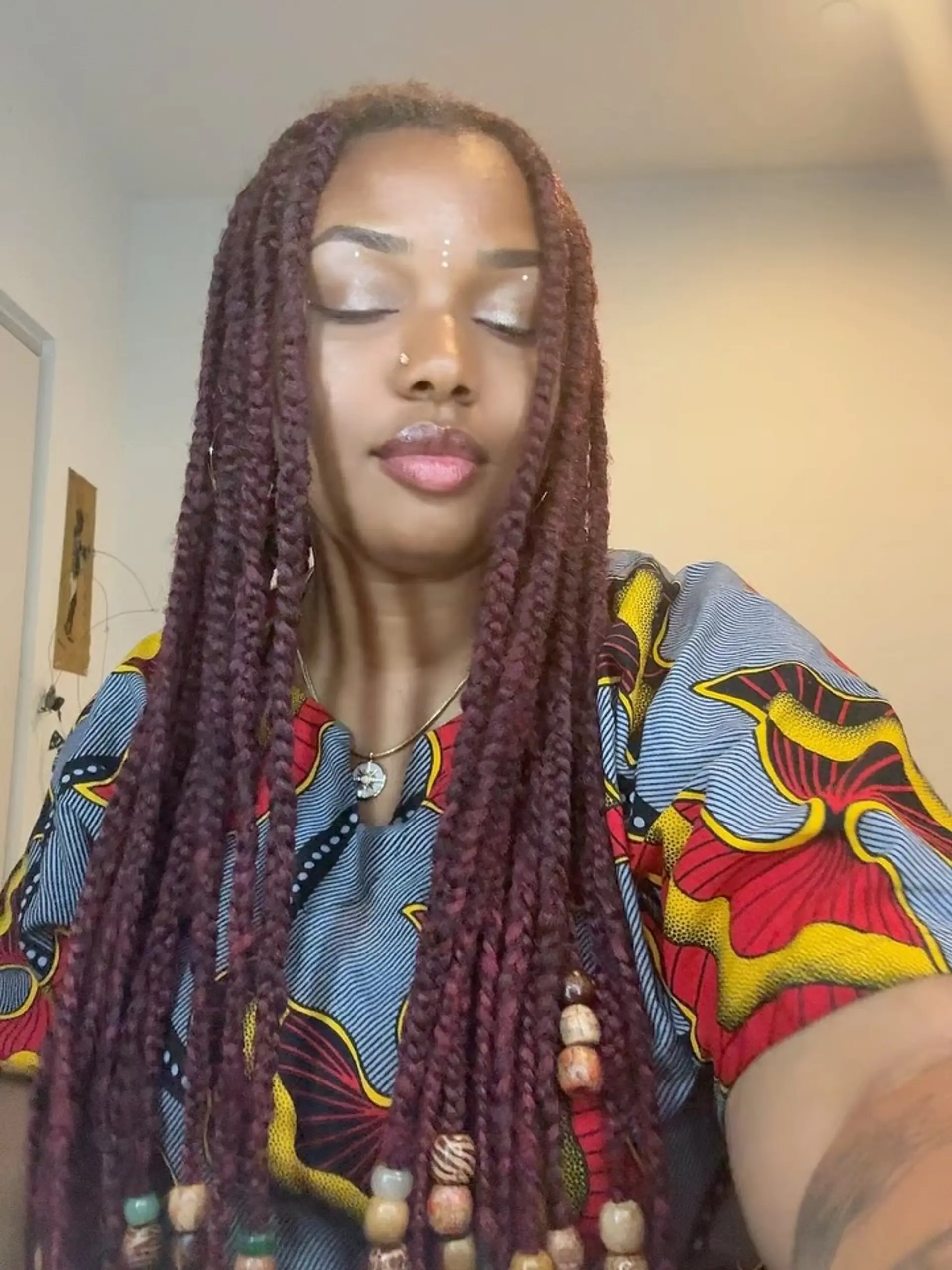 Long burgundy box braids finished with wooden and patterned decorative beads at the ends. 1