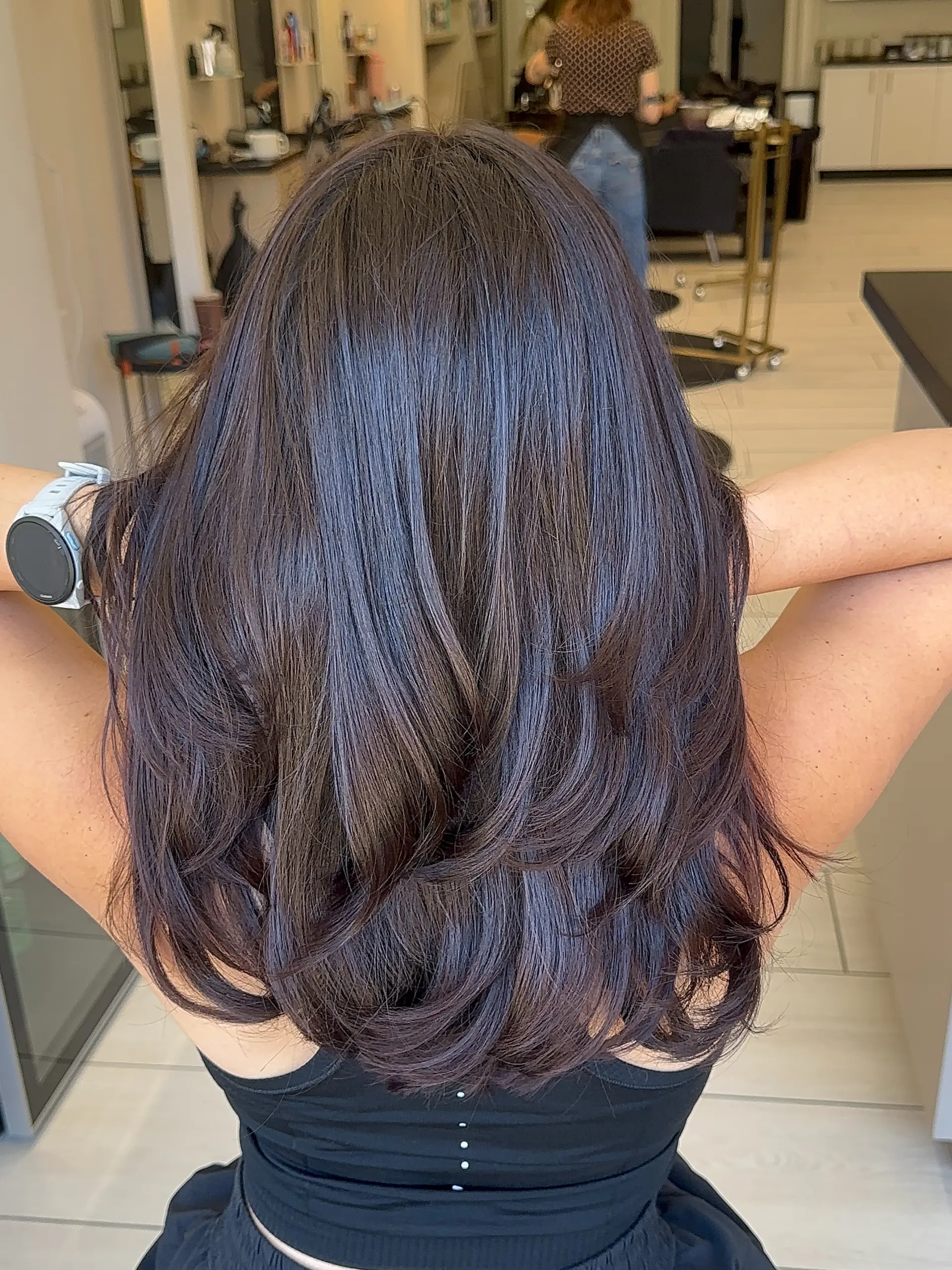 Rich espresso brunette hair cut in cascading layers with polished, curved ends. 1
