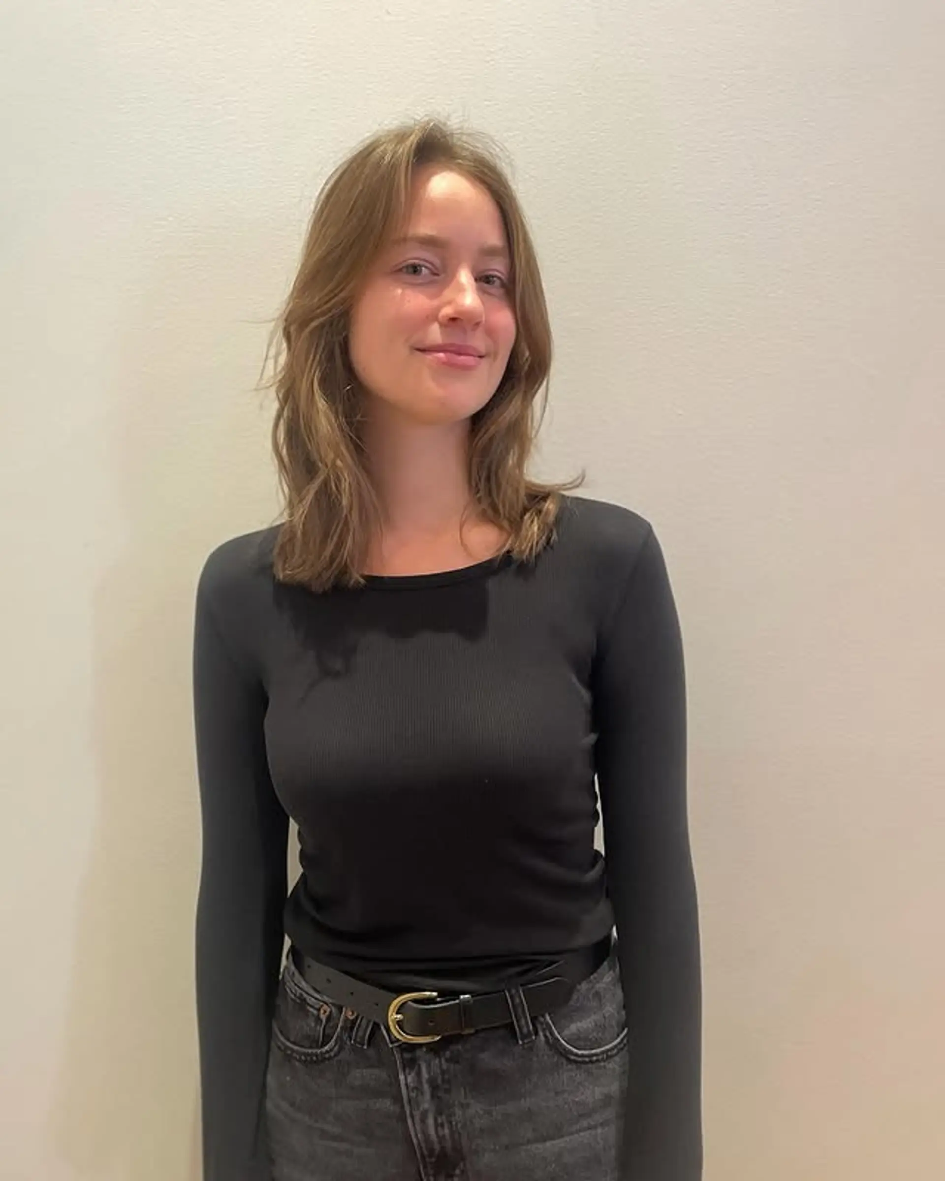 A medium-length, wavy hairstyle with subtle layering throughout the hair. 1