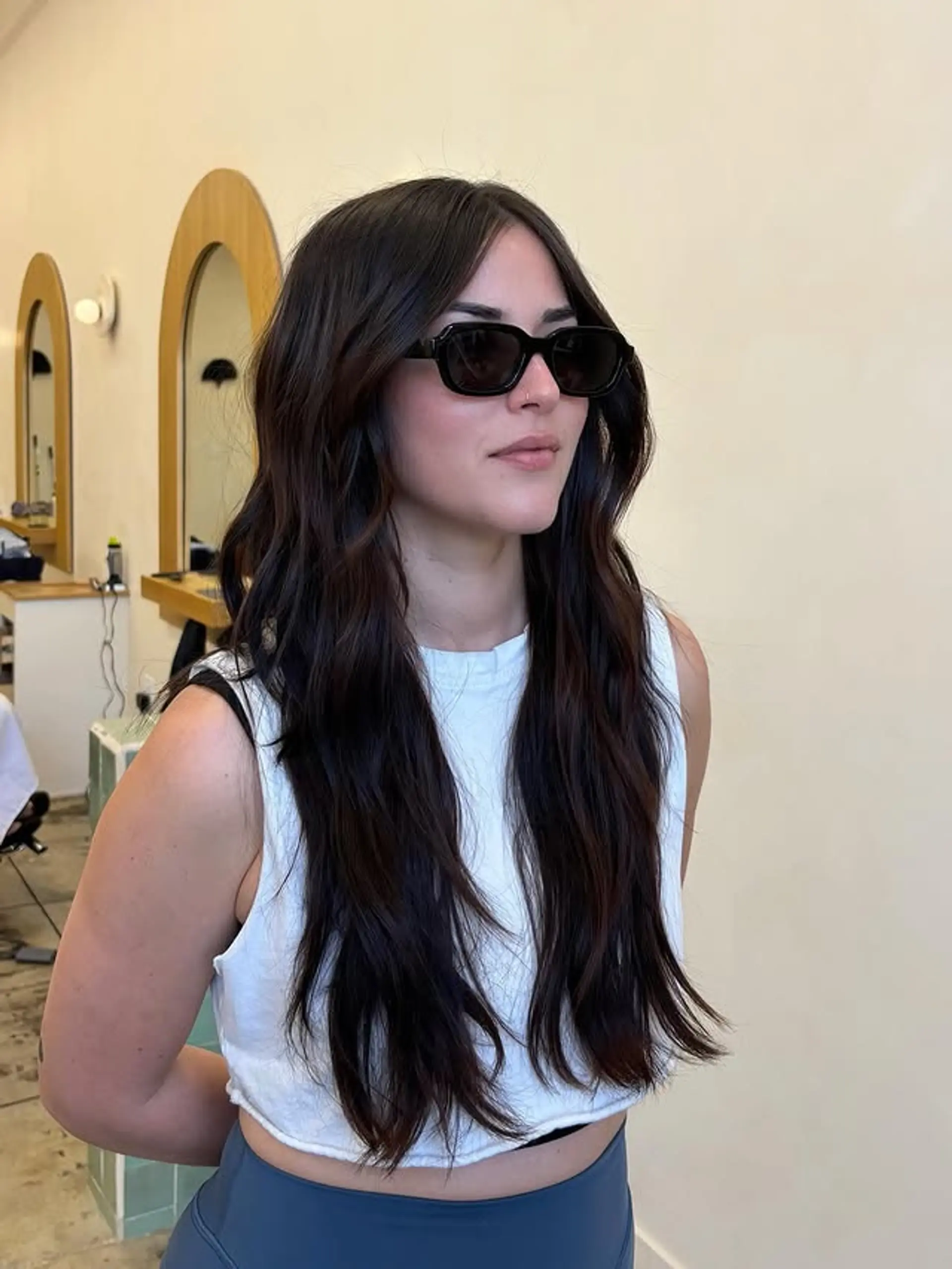 Long wavy hairstyle with face-framing layers and curtain bangs. 1