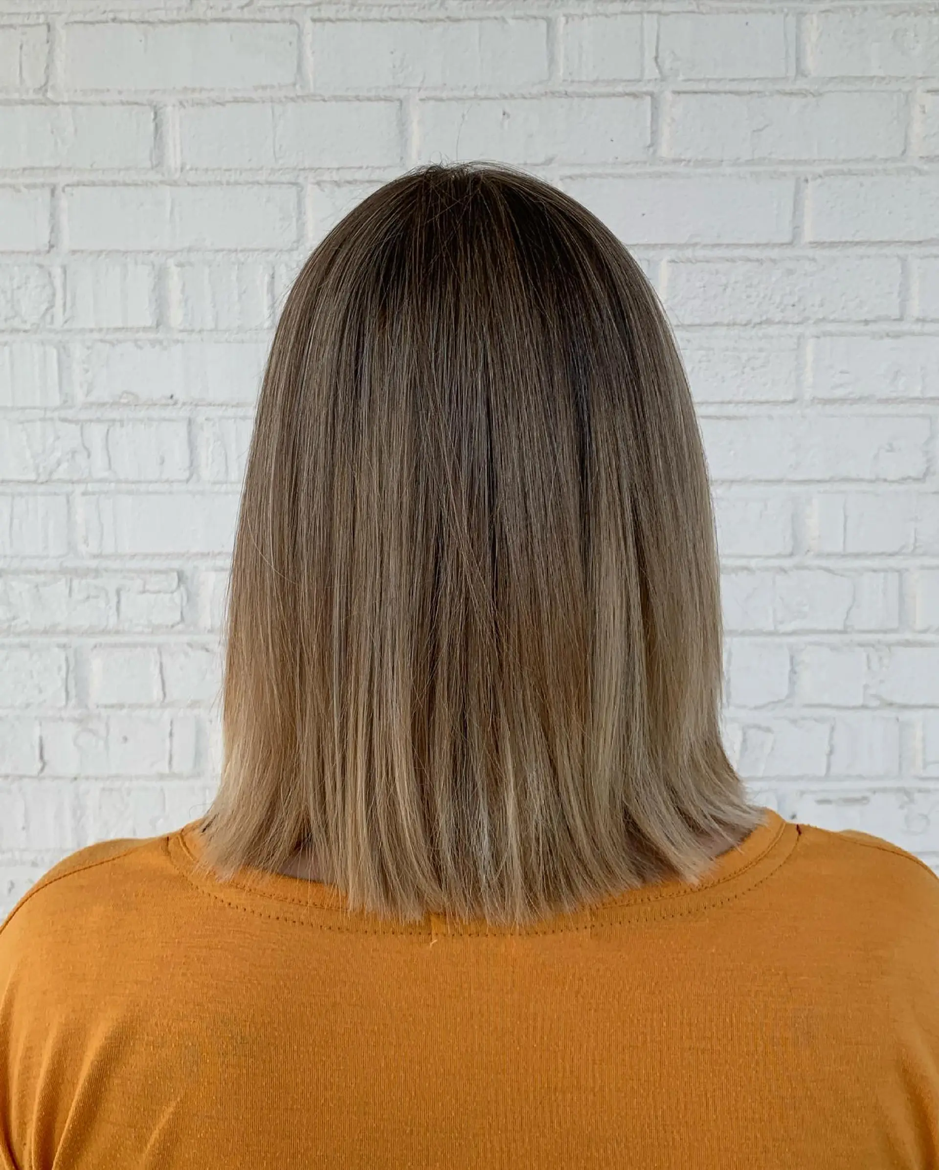 Collarbone-length blunt lob styled straight with a seamless balayage transitioning to soft beige blonde ends. 1