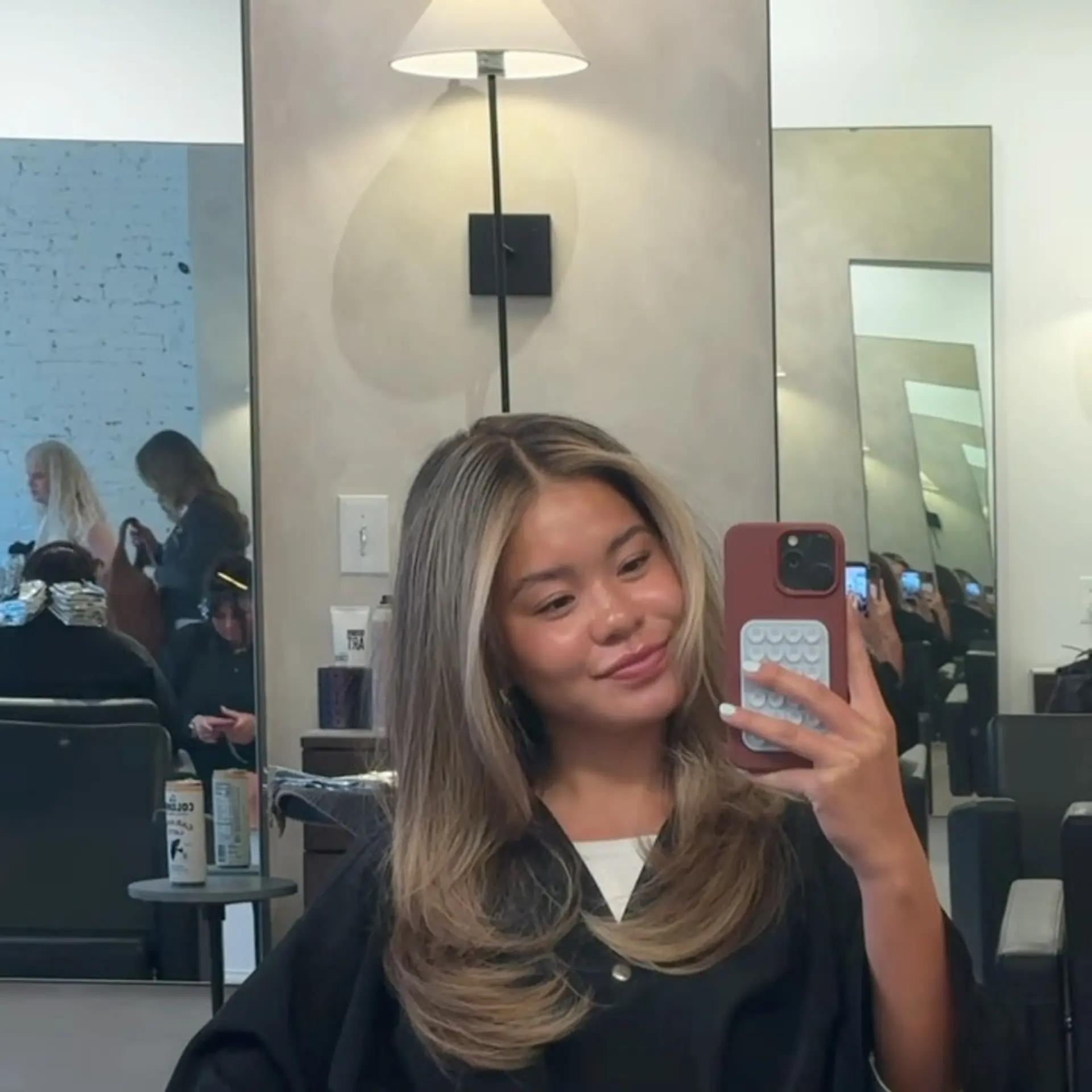 A dimensional bronde look with face-framing layers and a smooth, voluminous blowout curled inward at the ends. 1