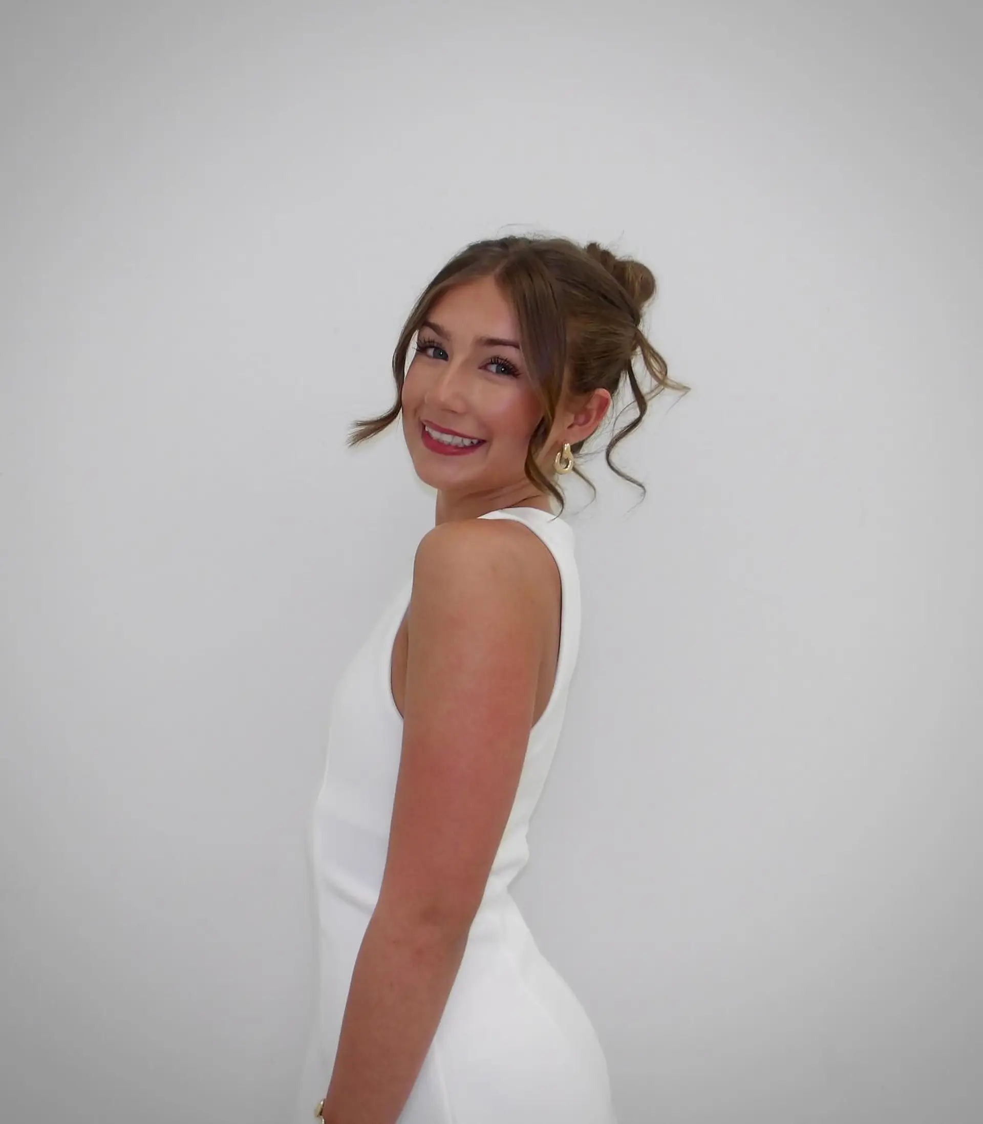A graceful updo featuring soft, loose curled tendrils framing the face and around the ears. 1
