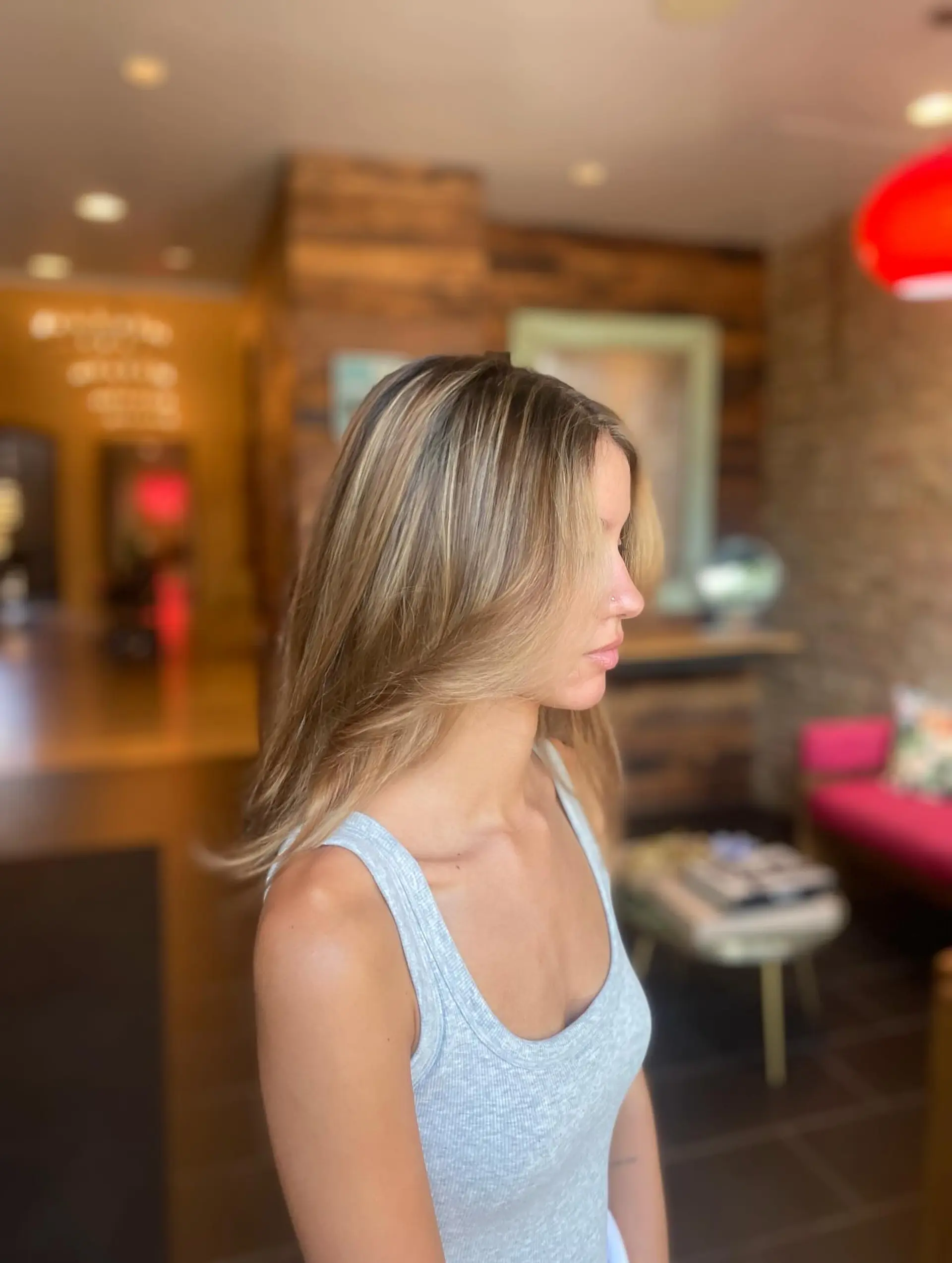 A medium-length cut with layers and face-framing pieces. Bronde color created with highlights to add dimension. 2