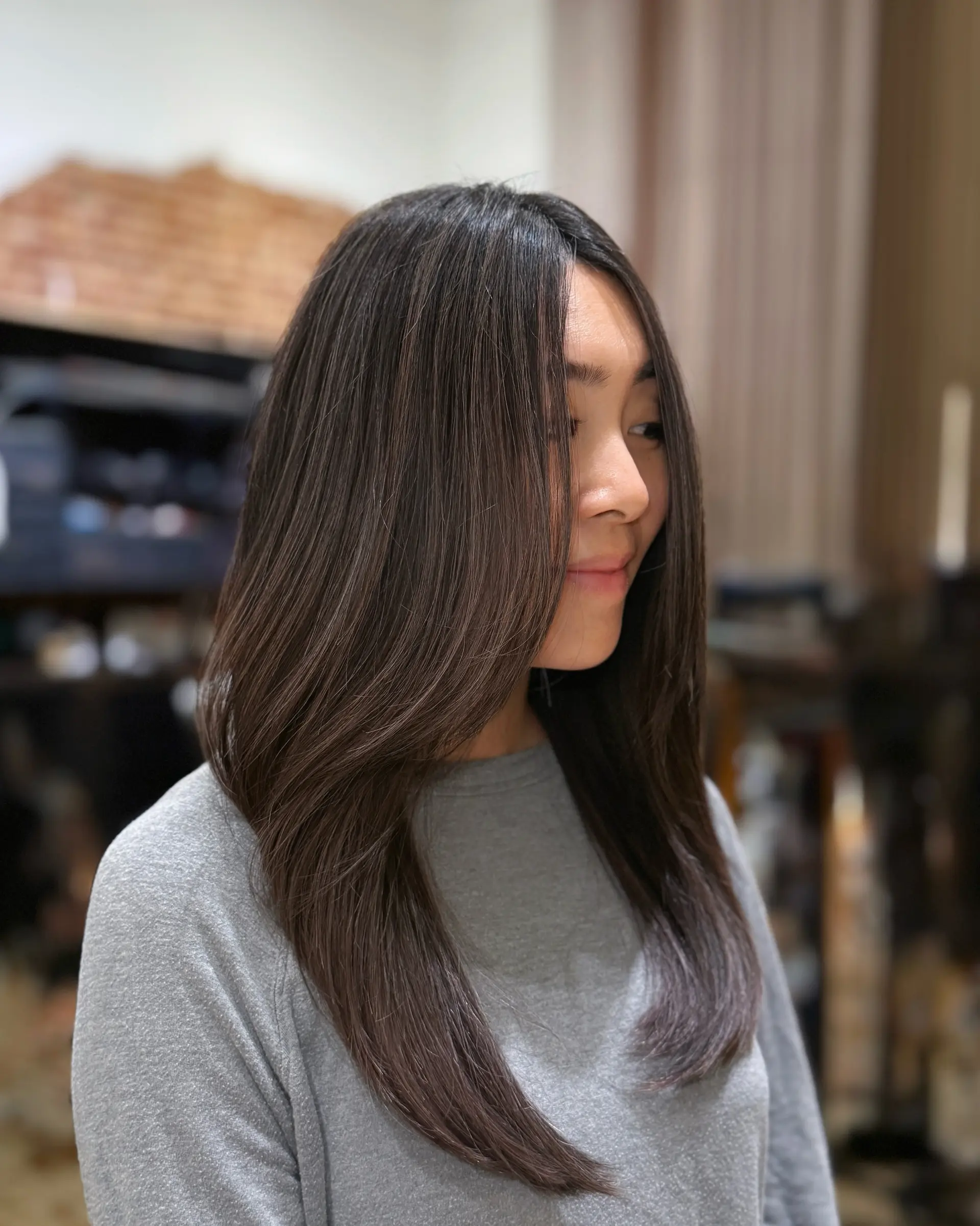 A dimensional brunette look featuring soft, seamless foilyage highlights for added depth and a healthy, polished shine. 1