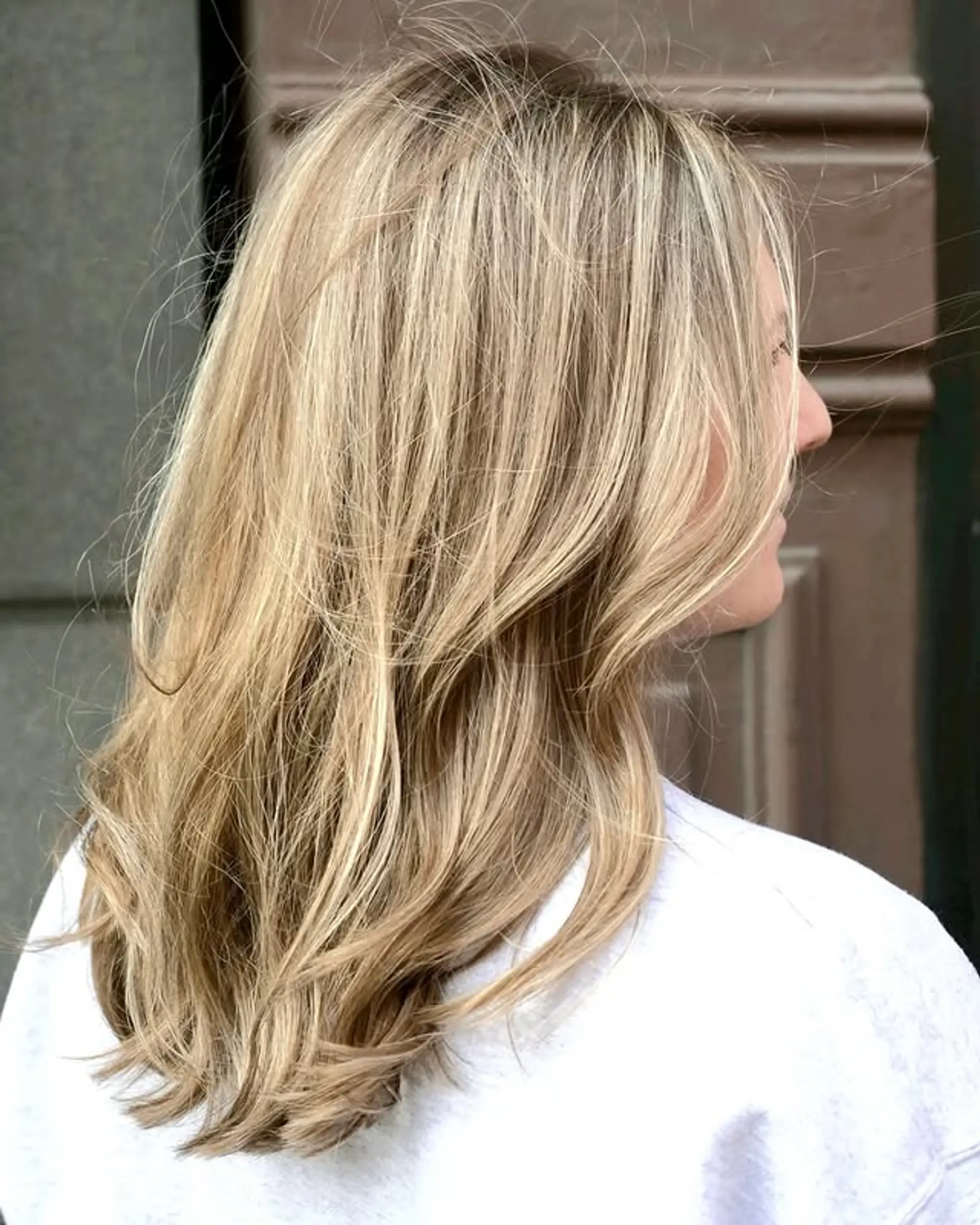 Medium-length layered cut with soft, beachy waves and blonde highlights. 1