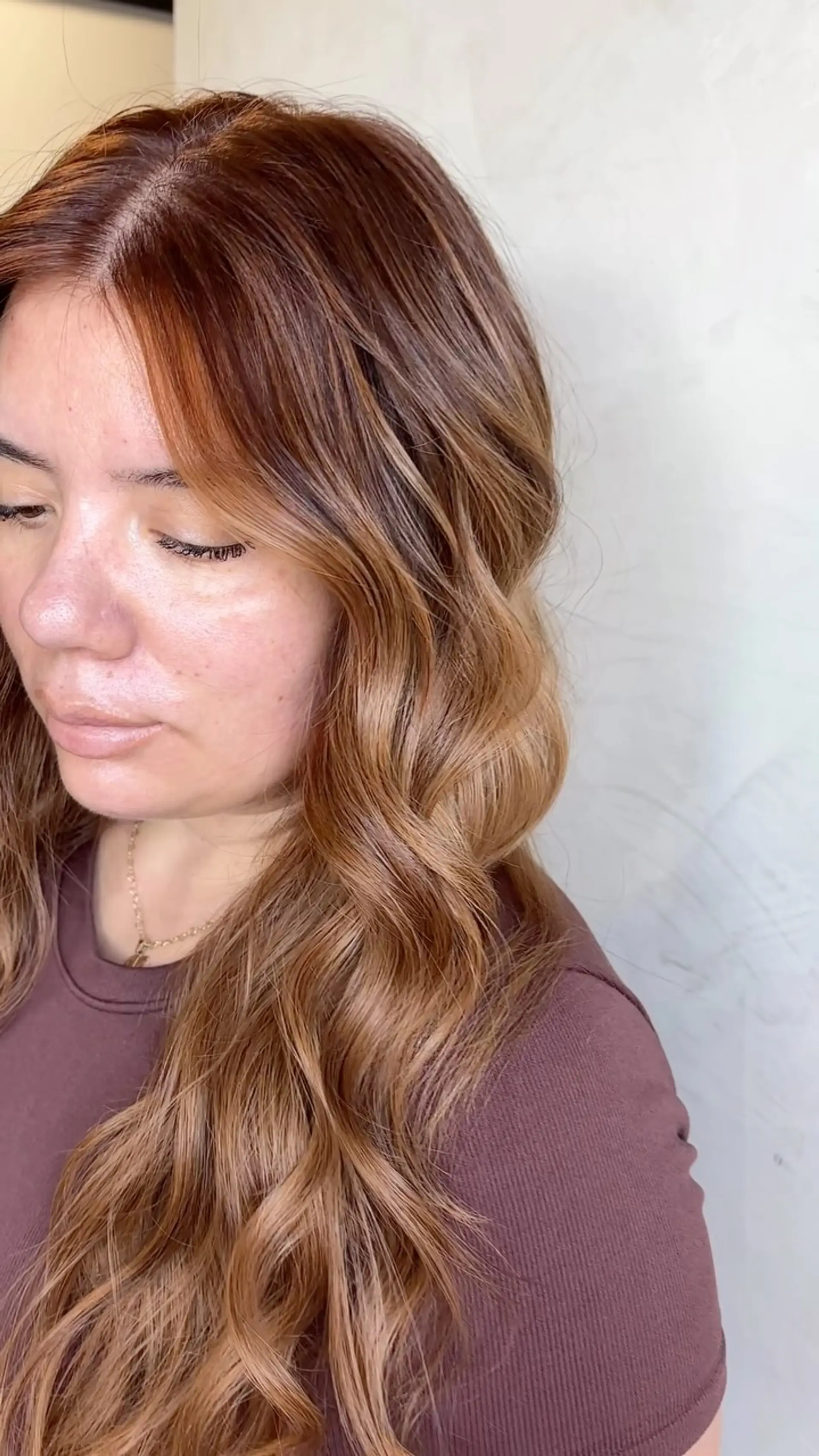 Long hair featuring warm strawberry blonde and copper tones blended over a light brown base, styled in soft loose waves. 1