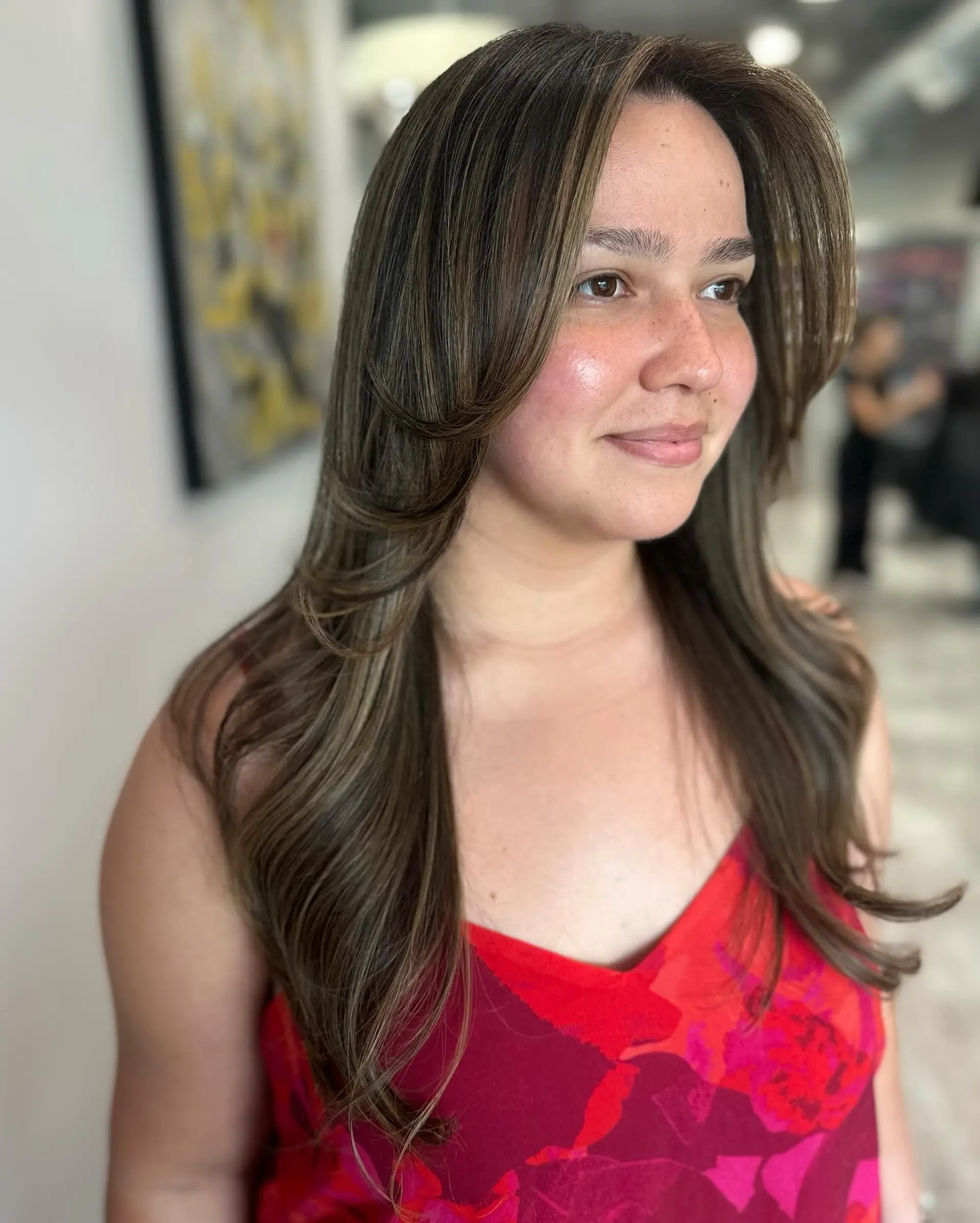 A long layered haircut with face-framing layers and subtle highlights for added dimension. 1