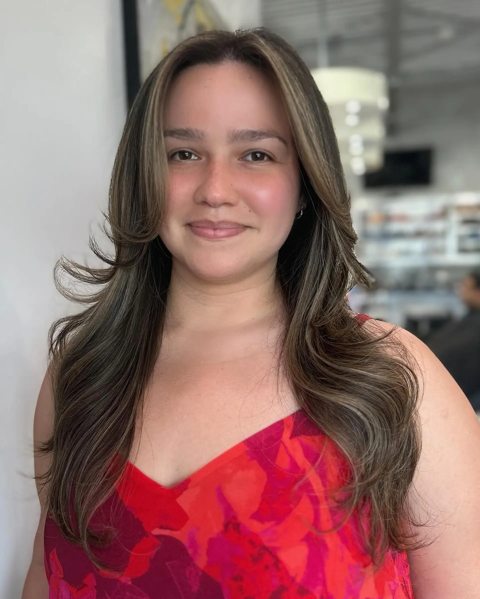 A long layered haircut with face-framing layers and subtle highlights for added dimension. 2