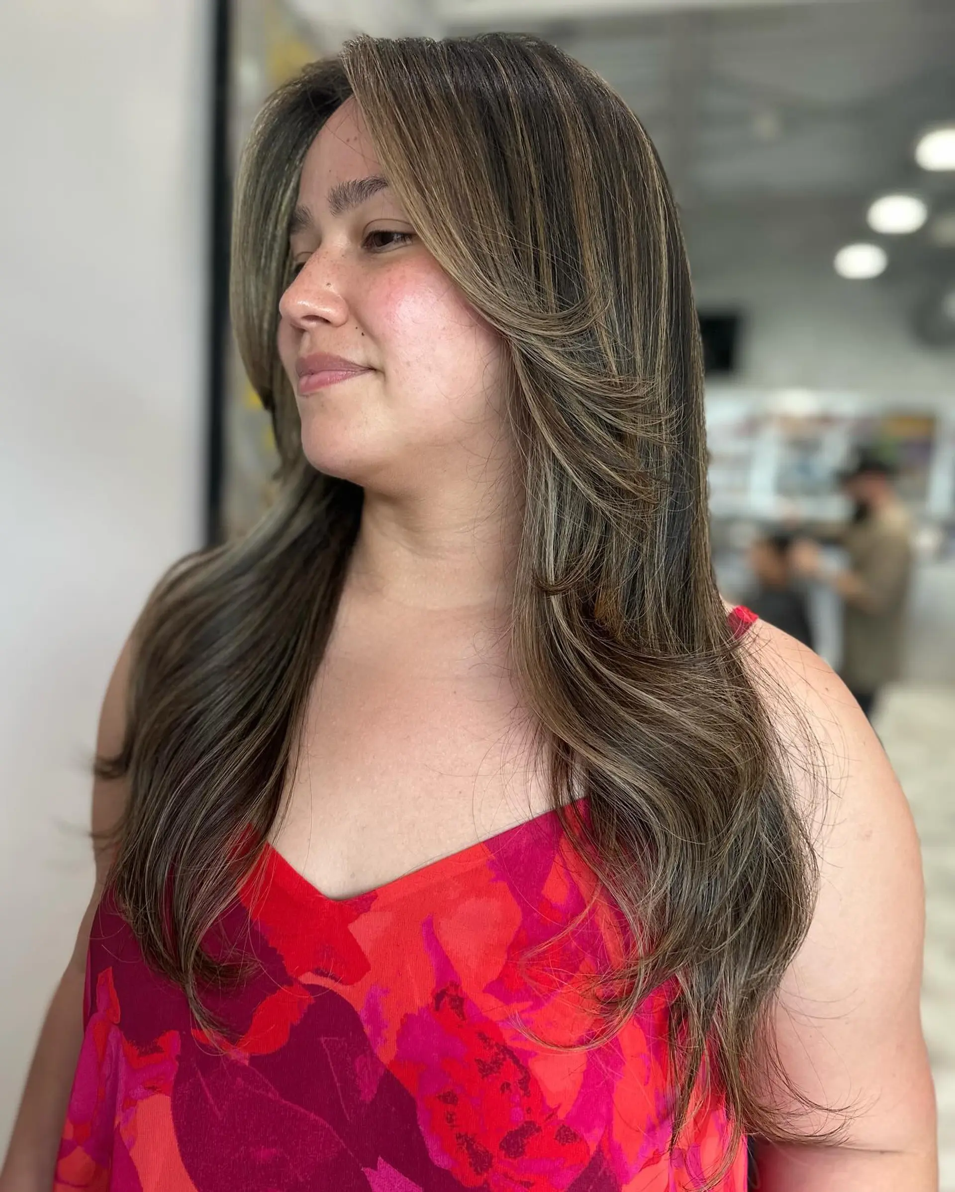 A long layered haircut with face-framing layers and subtle highlights for added dimension. 3