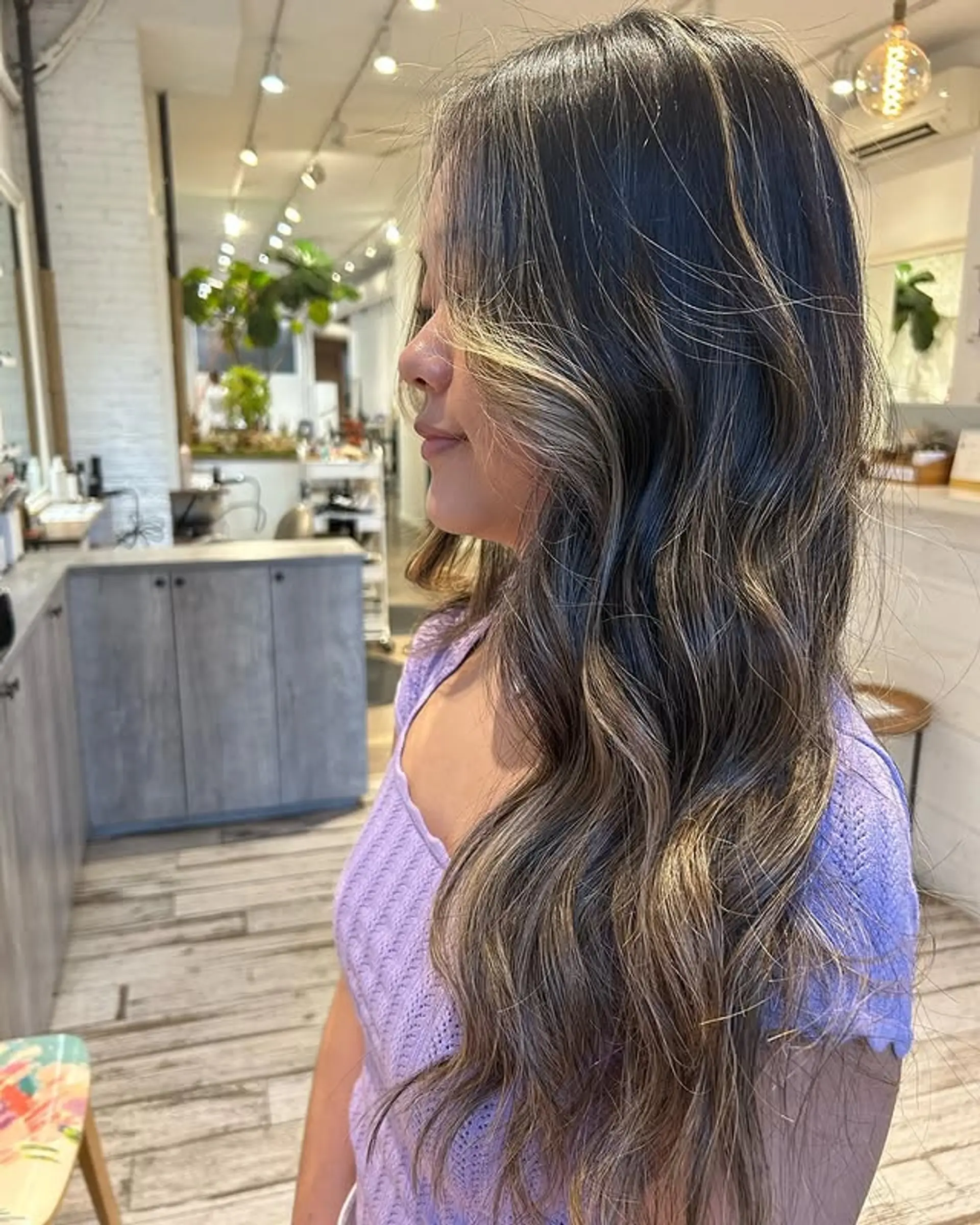 Long wavy hair with a balayage that has brown roots transitioning into blonde highlights. 1