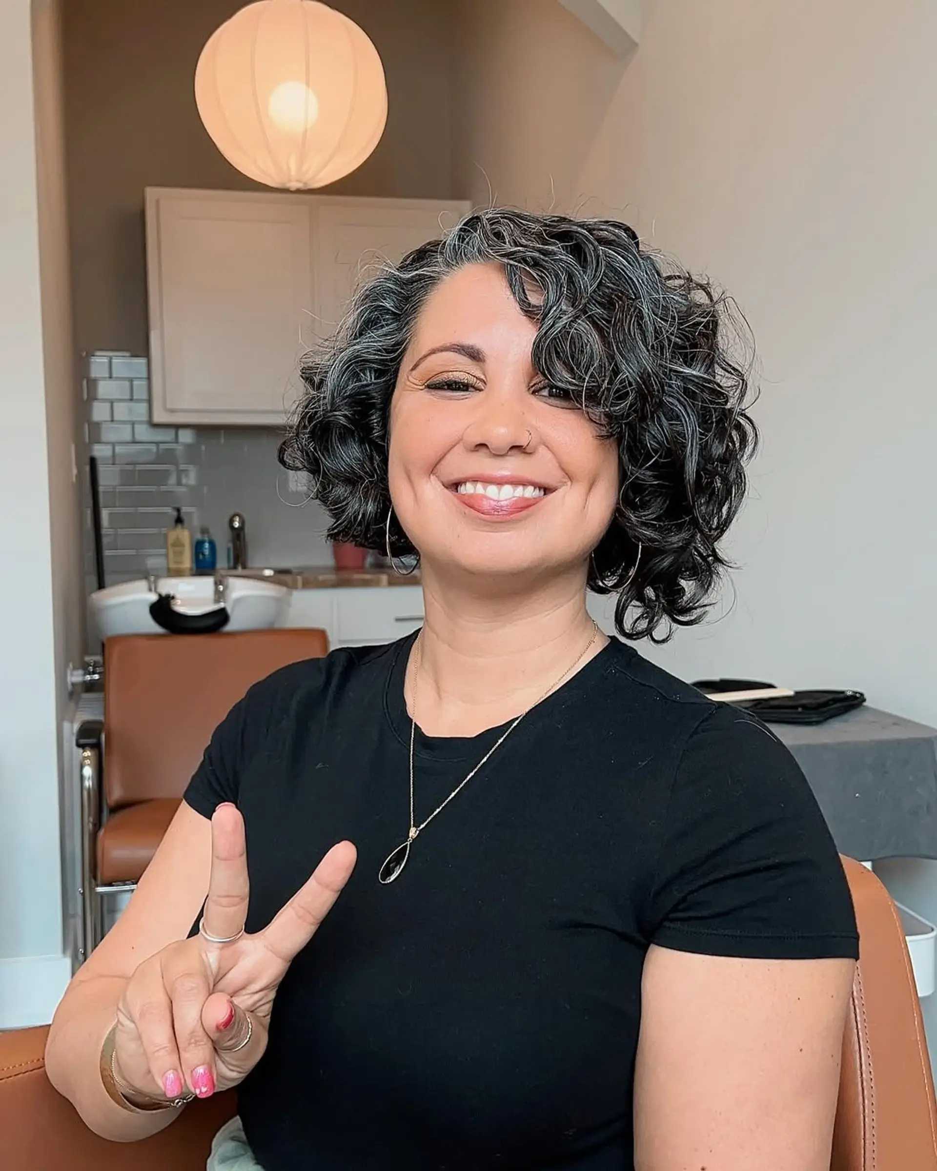 A voluminous short curly bob, characterized by defined, bouncy curls and layers that create shape and movement. It's a chic, low-maintenance style that highlights natural texture. 2