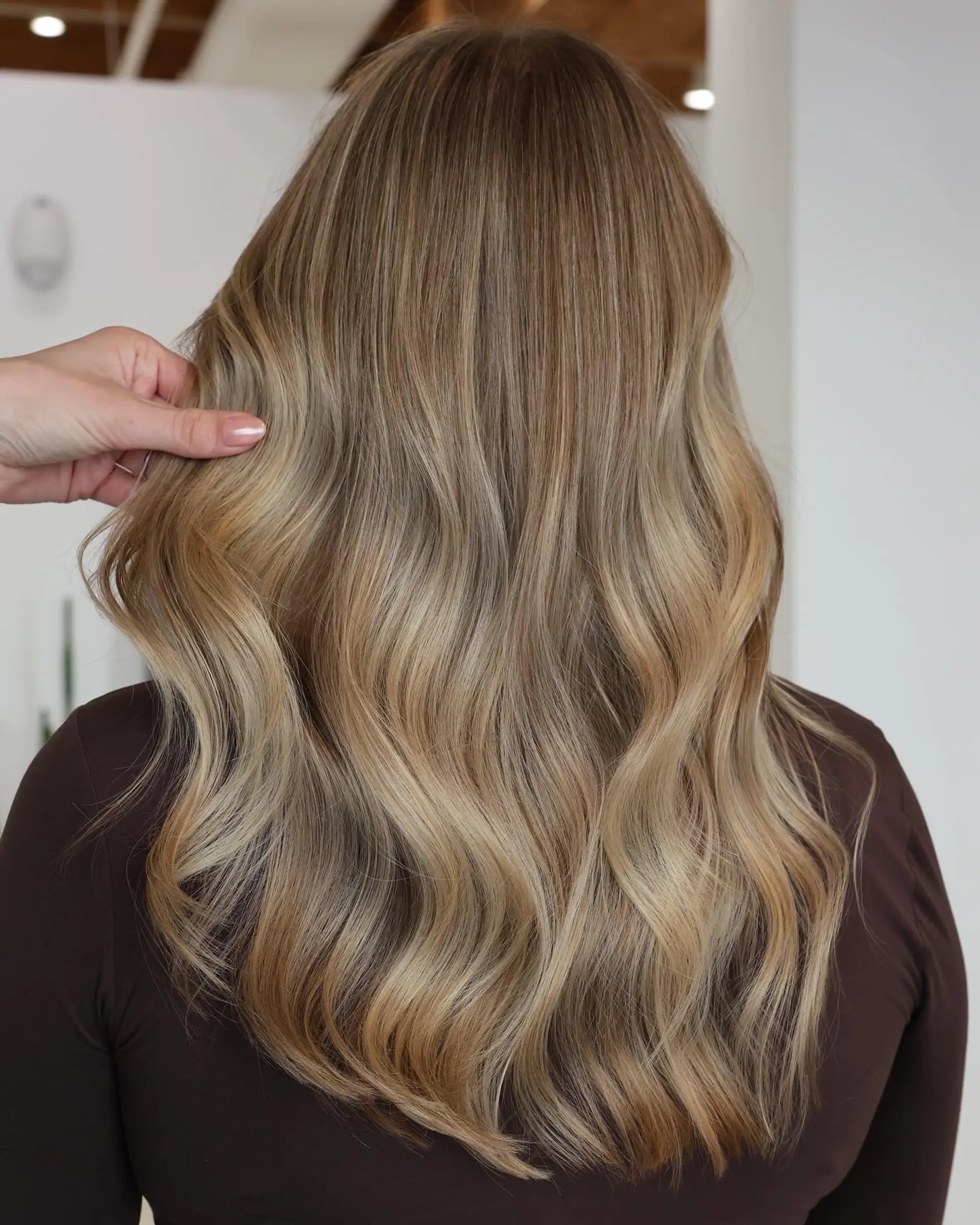 Medium length wavy hair with blonde balayage. 5