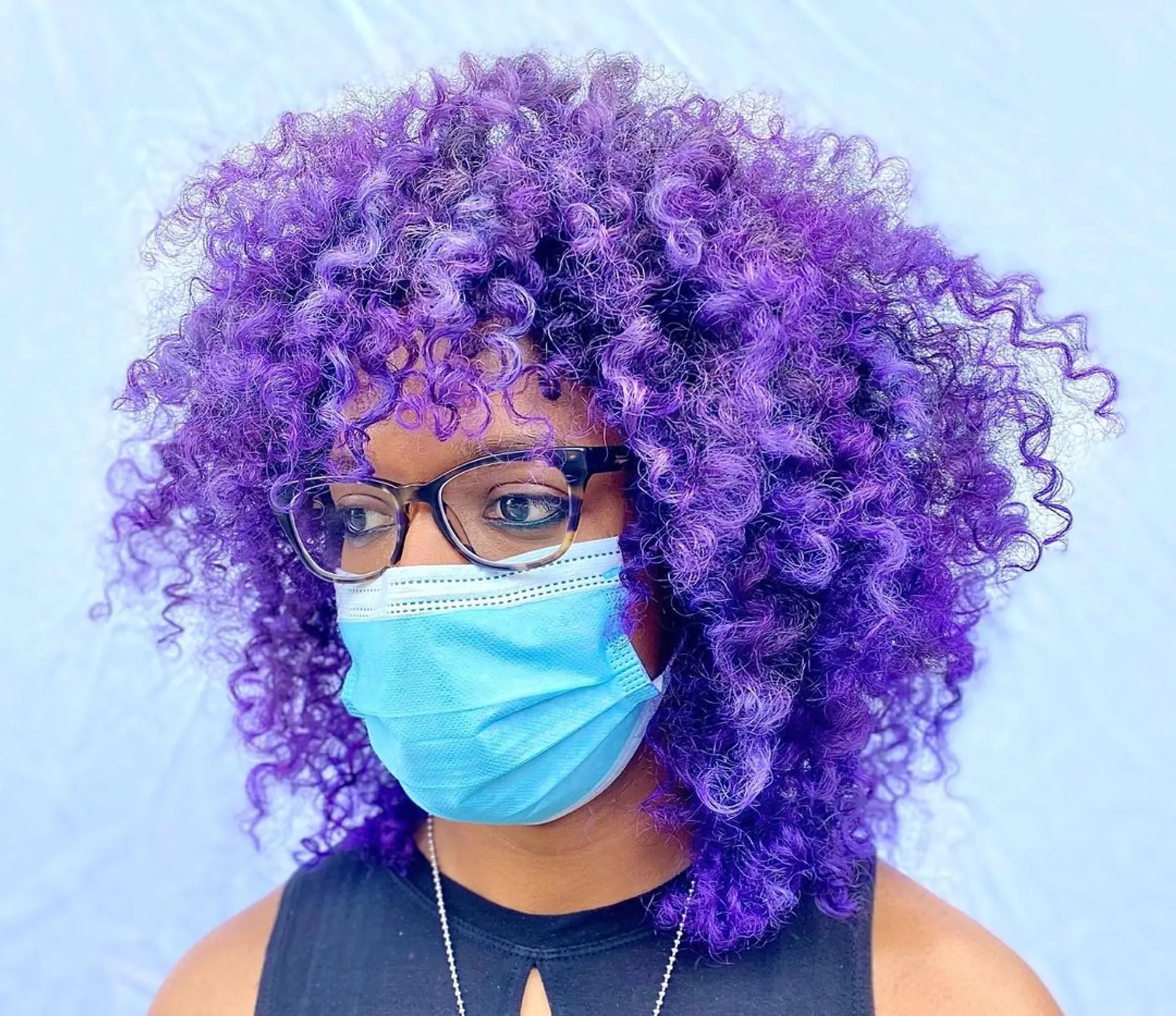 A vibrant medium-length curly hairstyle with rich purple color and voluminous curls. 1