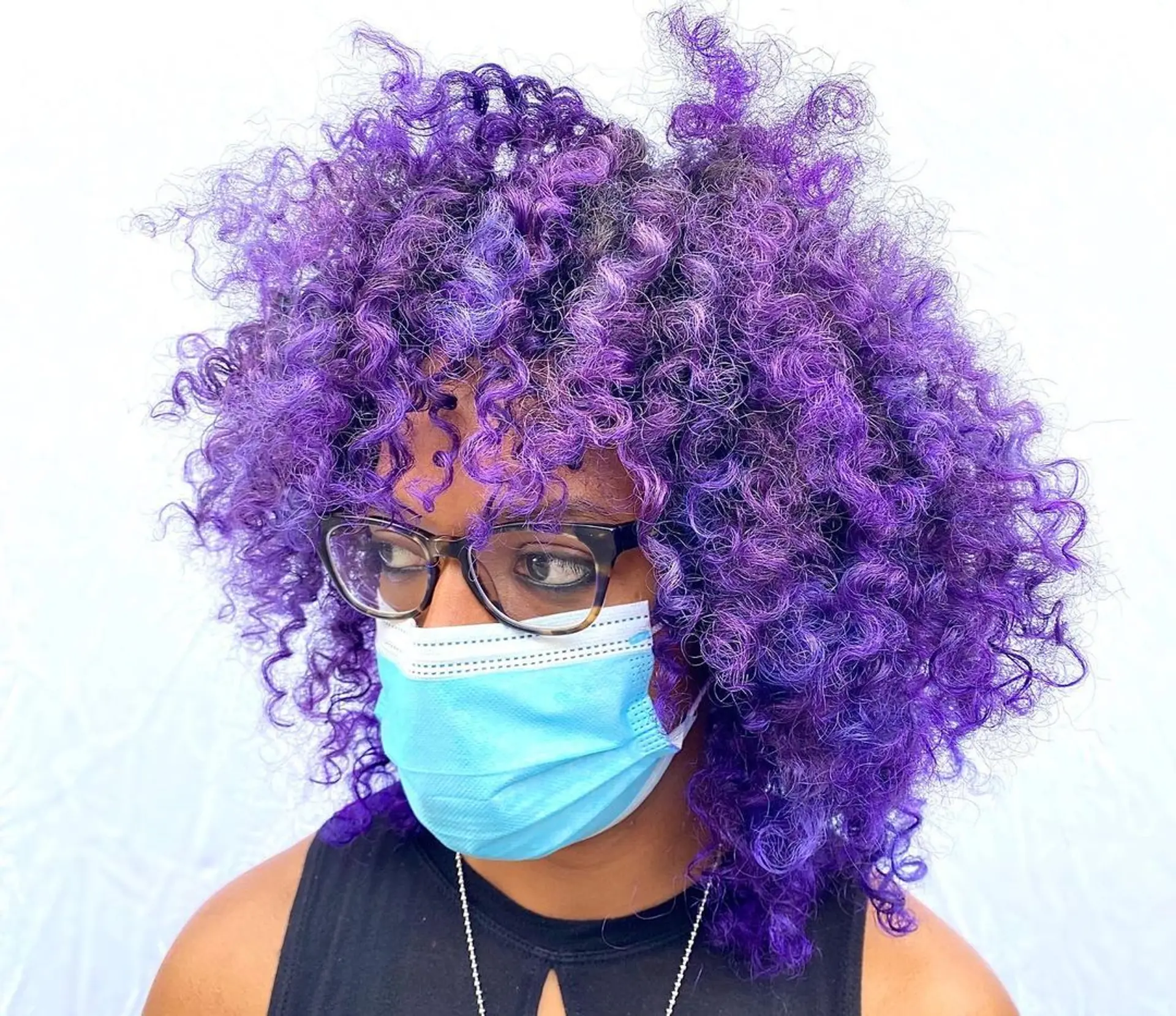 A vibrant medium-length curly hairstyle with rich purple color and voluminous curls. 2