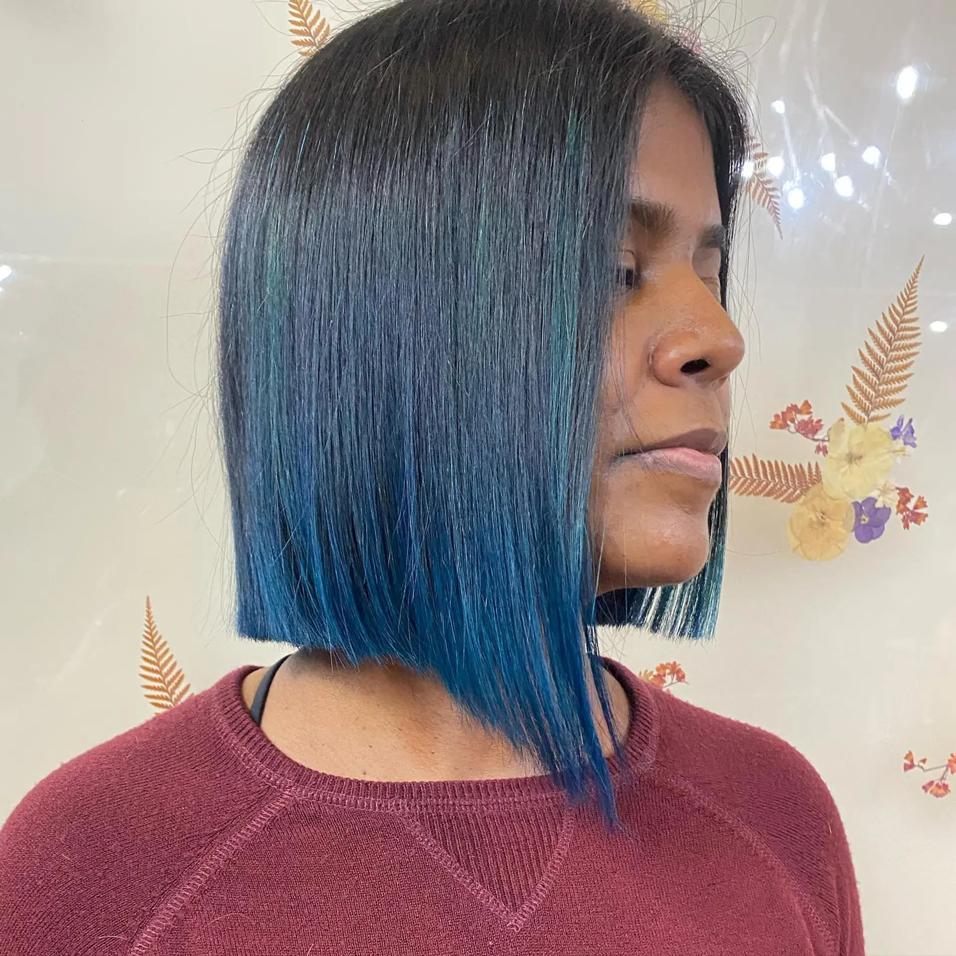 A sleek, sharp angled bob featuring deep black-brown roots blending into vibrant ocean blue and teal dipped ends. 1