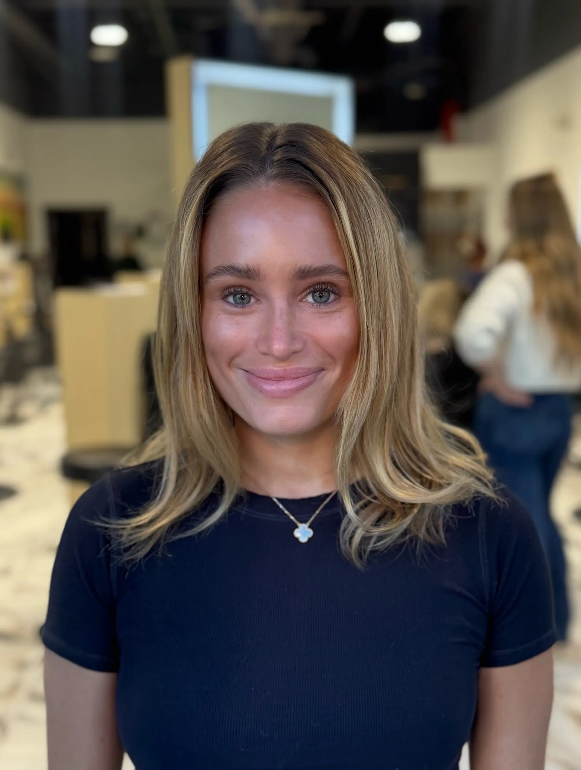 Medium-length collarbone cut with soft face-framing layers and flipped ends, colored in warm blonde highlights. 1