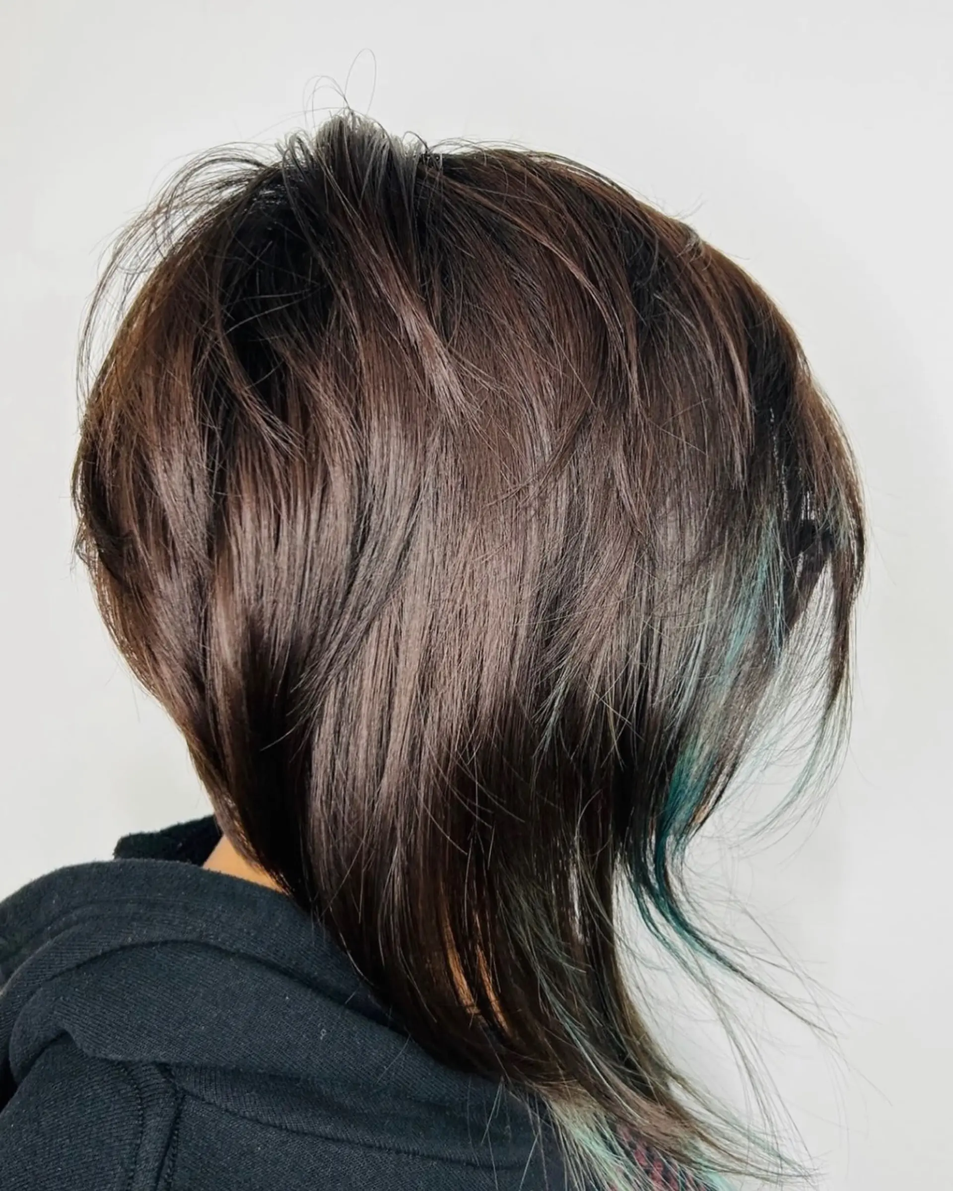 A medium-length textured shag with feathered layers in dark brown and subtle teal peekaboo highlights. 1