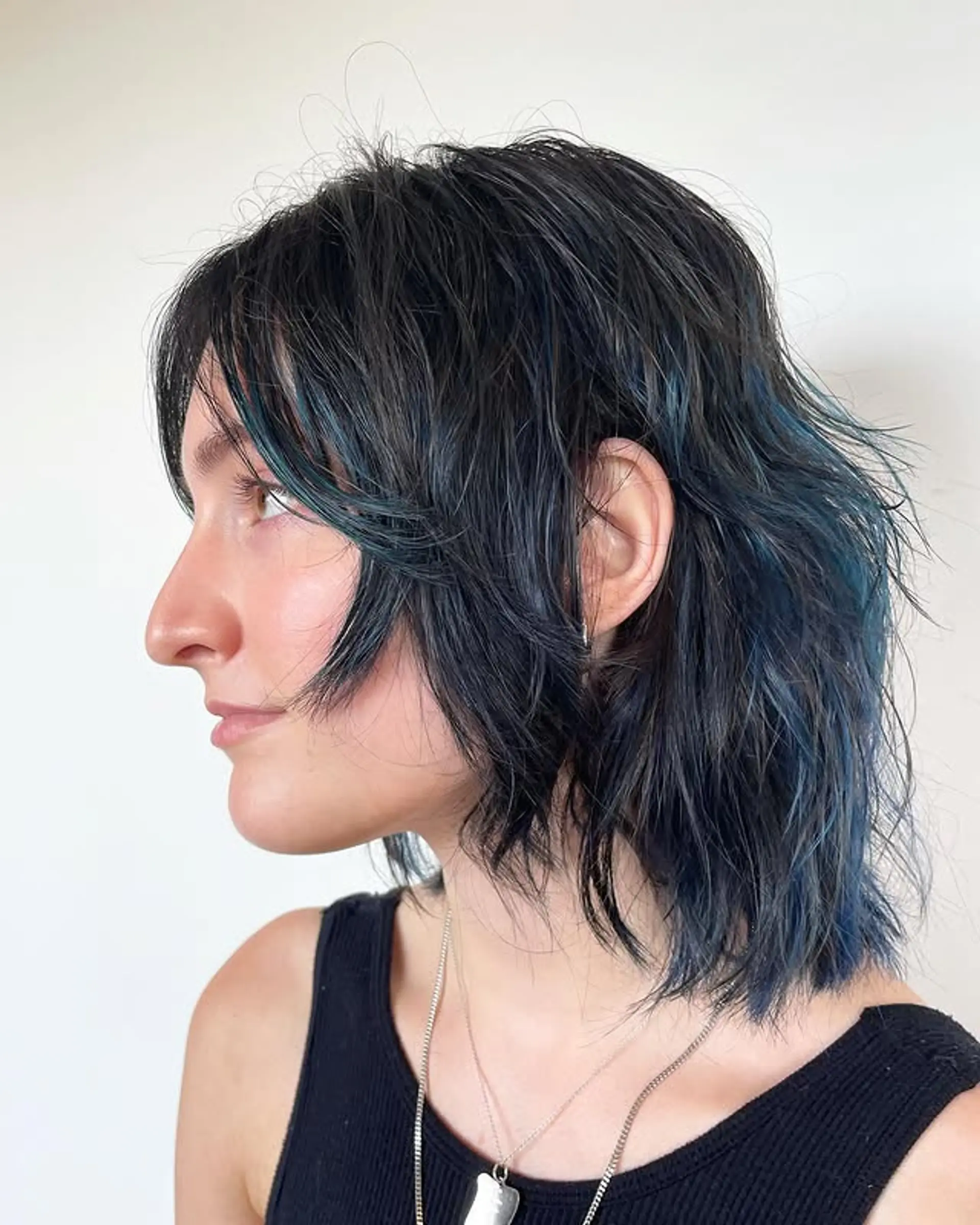 A trendy shag haircut with choppy layers and vibrant blue highlights. 1